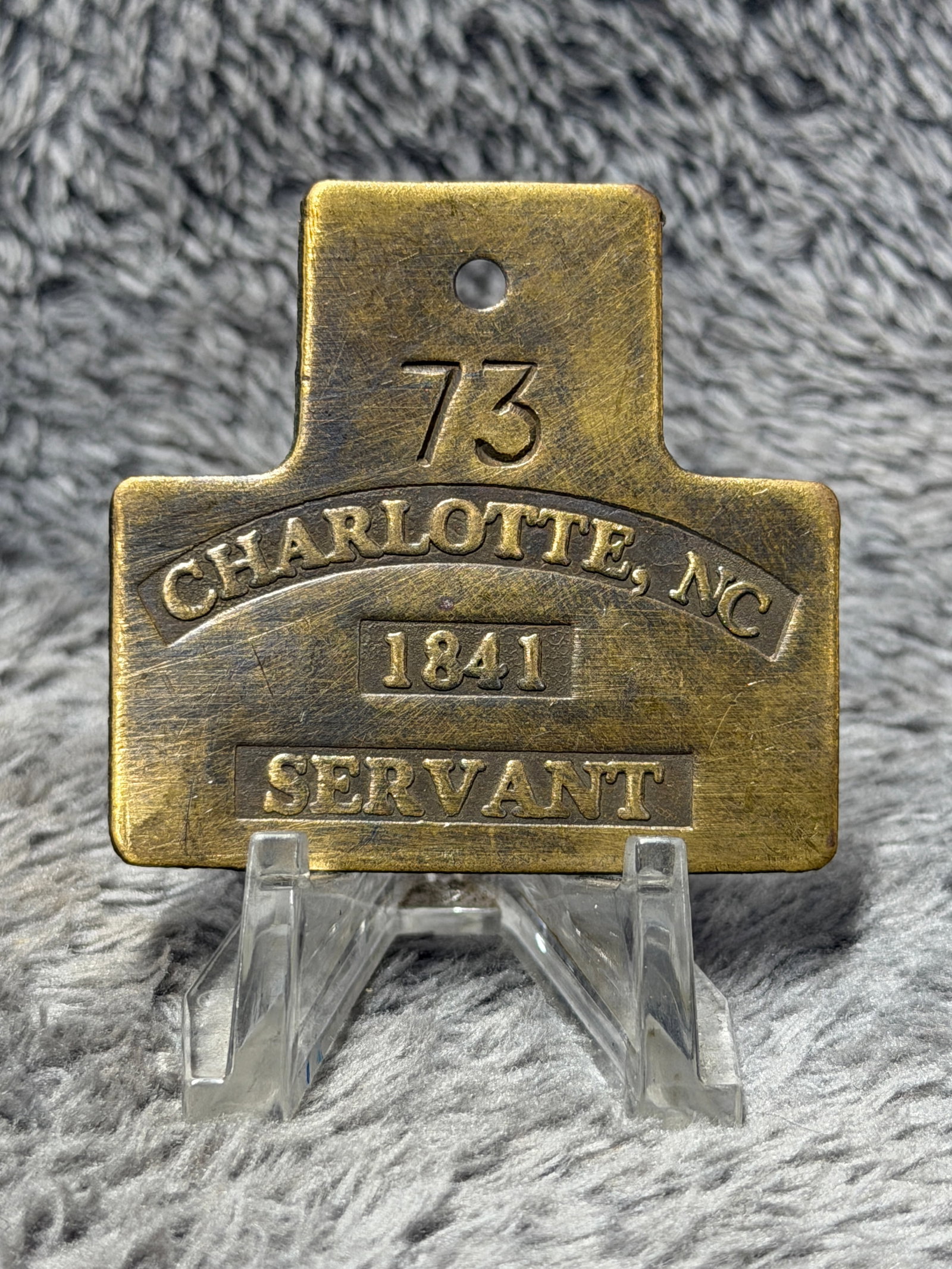 Civil War 1841 Charlotte, North Carolina Servant Identification Slave Tag No. 73: Civil War-era brass identification tag marked “73” at the top, with the face prominently inscribed “CHARLOTTE, NC,” “1841,” and “SERVANT.” The heavy rectangular brass f