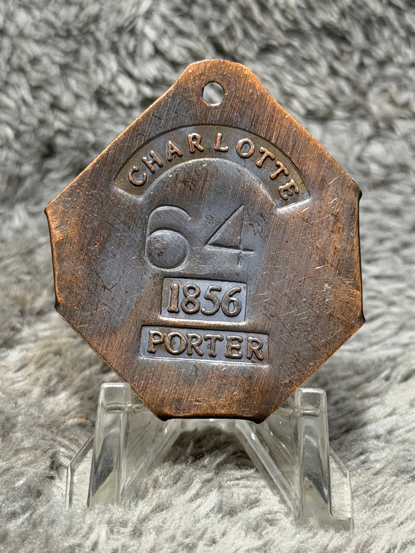 1856 Charleston, South Carolina Slave Hire Tag – Porter No. 64: Charleston, South Carolina slave hire tag prominently marked “CHARLOTTE” across the upper arched panel, with the large identification number “64,” the date “1856,” and occupati