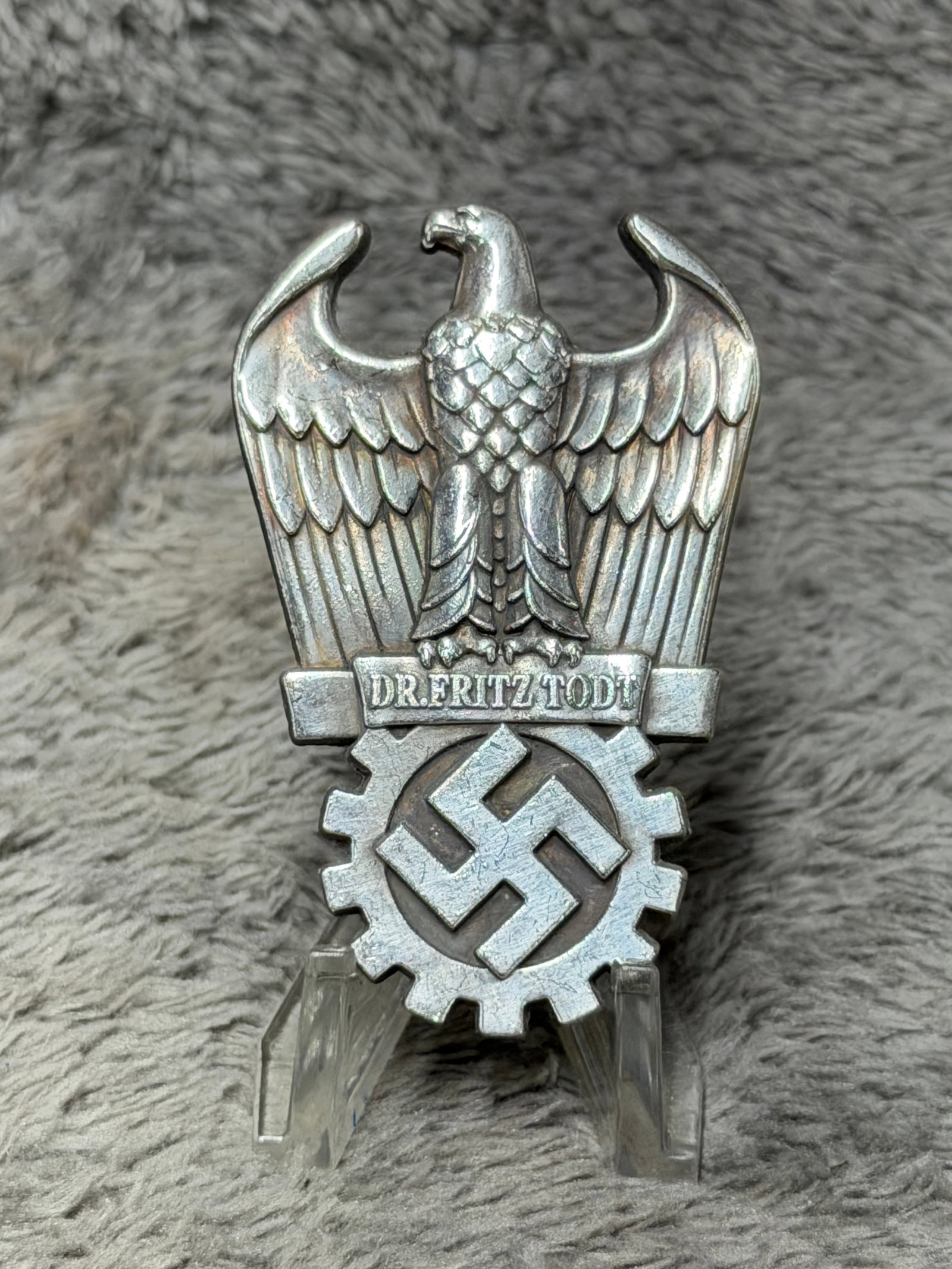 WWII German DAF Dr. Fritz Todt Organization Badge – Eagle & Cogwheel Emblem: Striking WWII German organizational badge featuring a large raised national eagle with outstretched wings above a prominent cogwheel enclosing a swastika, an emblem closely associated with the German 