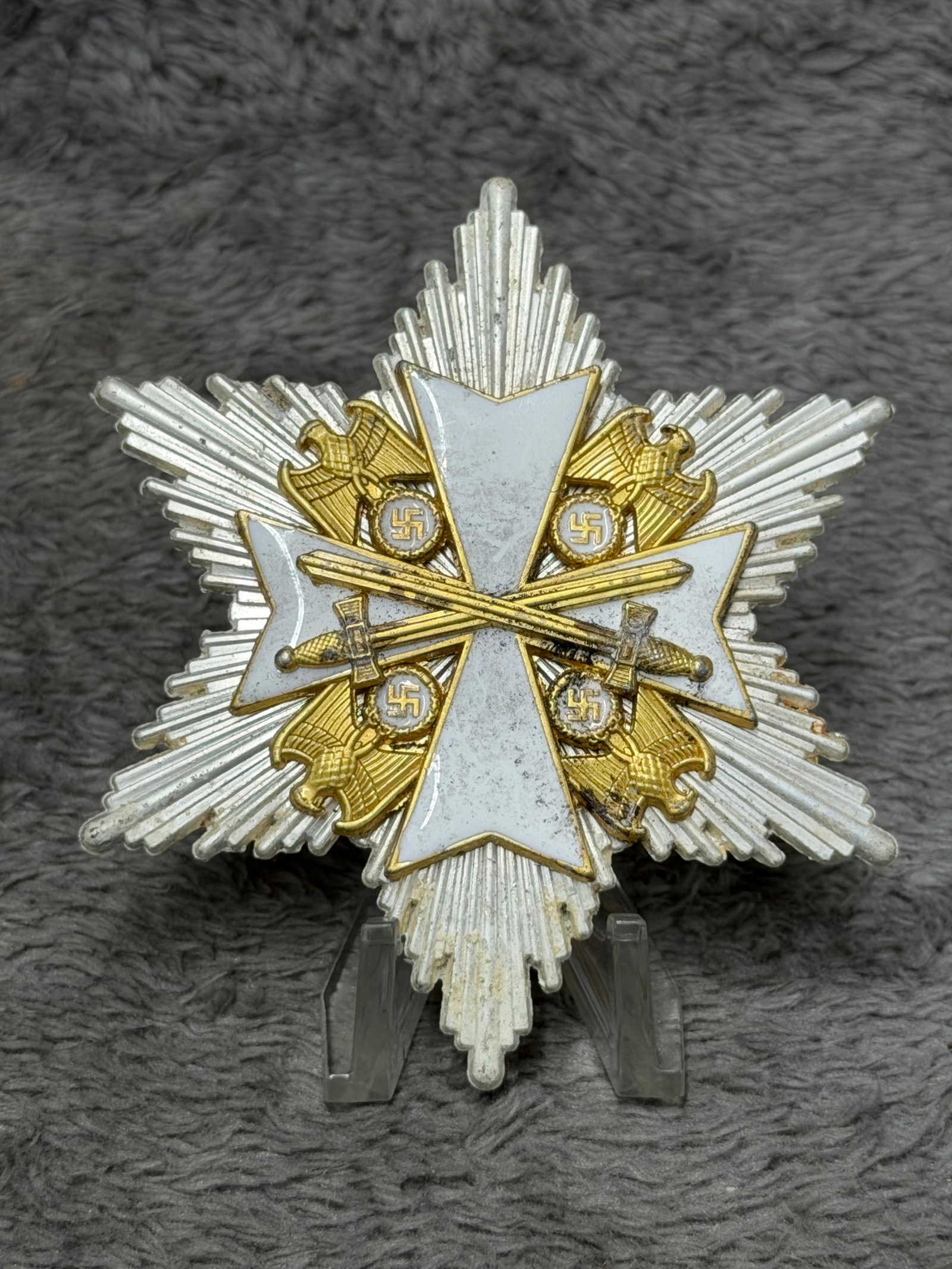 WWII German Order of the German Eagle Grand Cross Breast Star with Swords: Impressive WWII German multi-piece breast star featuring a large silver-toned radiating starburst surmounted by a white enameled cross with gilt borders. Positioned between the arms are four gilt Germ