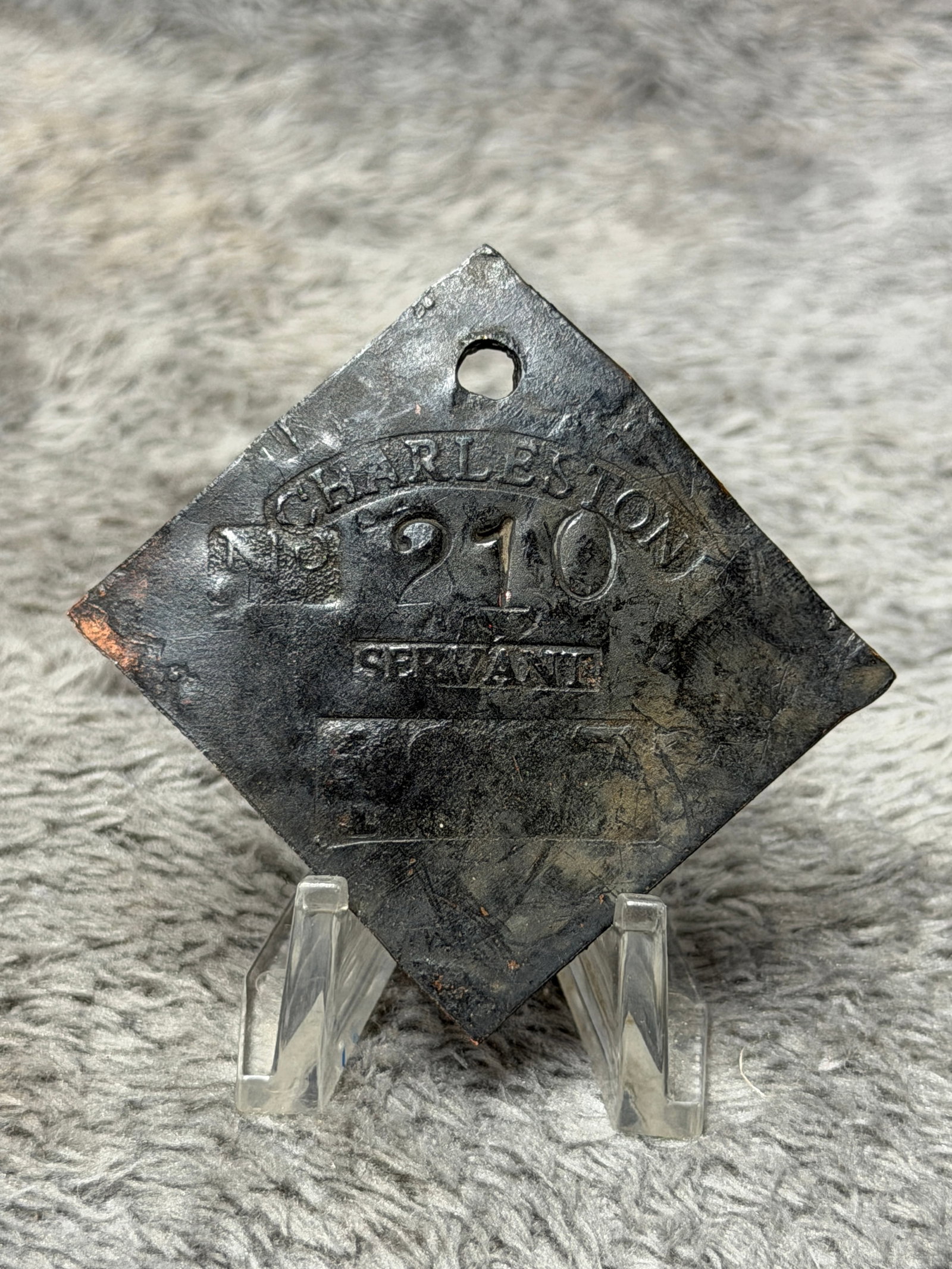 1817 Charleston No. 210 Servant Slave Identification Tag – Diamond-Shaped Copper Badge: Early 19th-century 1817 Charleston slave identification tag fashioned from a substantial copper or copper-alloy plate in a distinctive diamond-shaped form with a pierced suspension hole near the upper