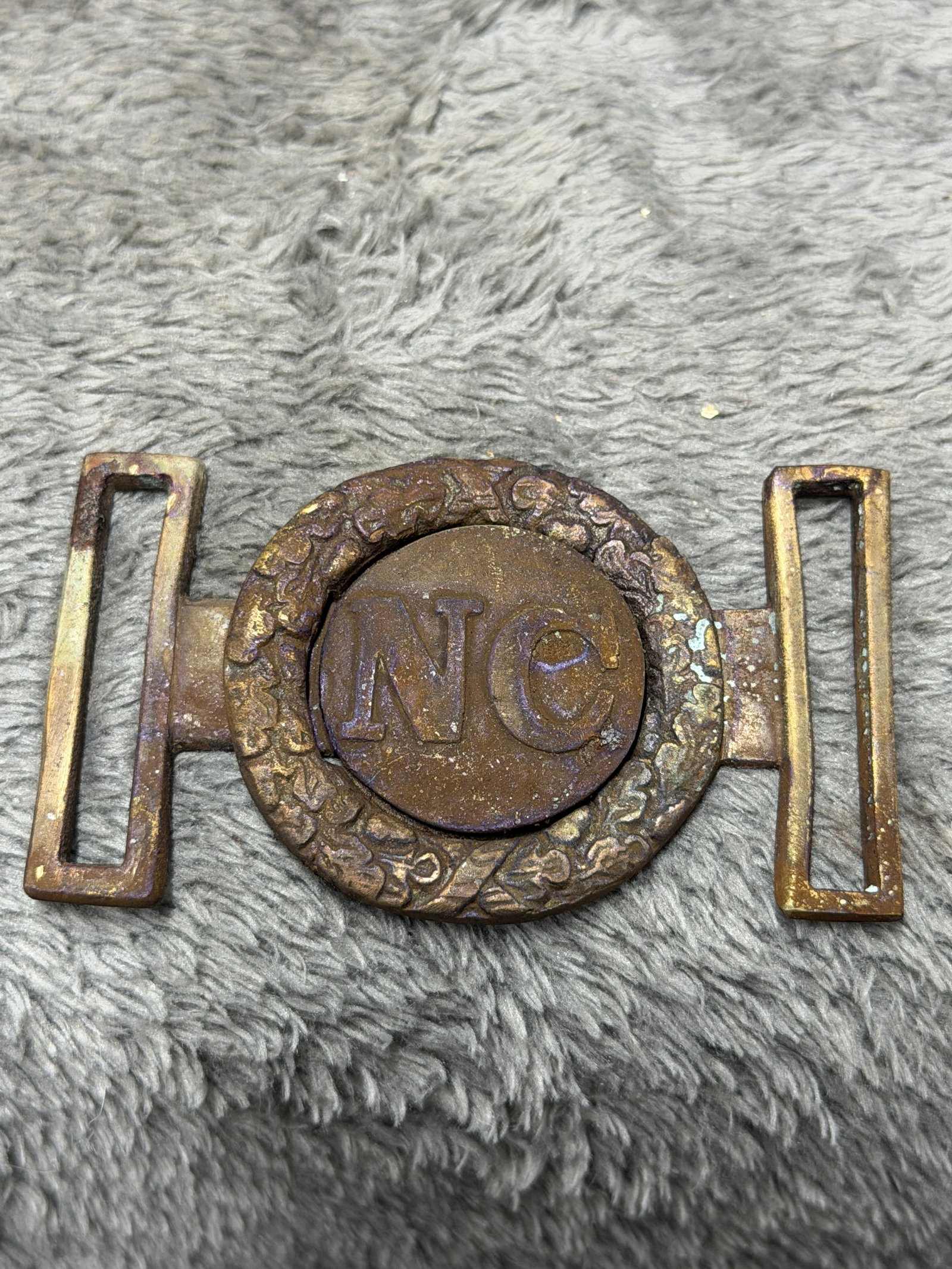 Civil War Confederate CSA North Carolina “NC?? Two-Piece Belt Buckle: Striking Civil War Confederate North Carolina belt buckle featuring a large circular centerpiece prominently embossed with the letters “NC” for North Carolina. The central disc fits within an 