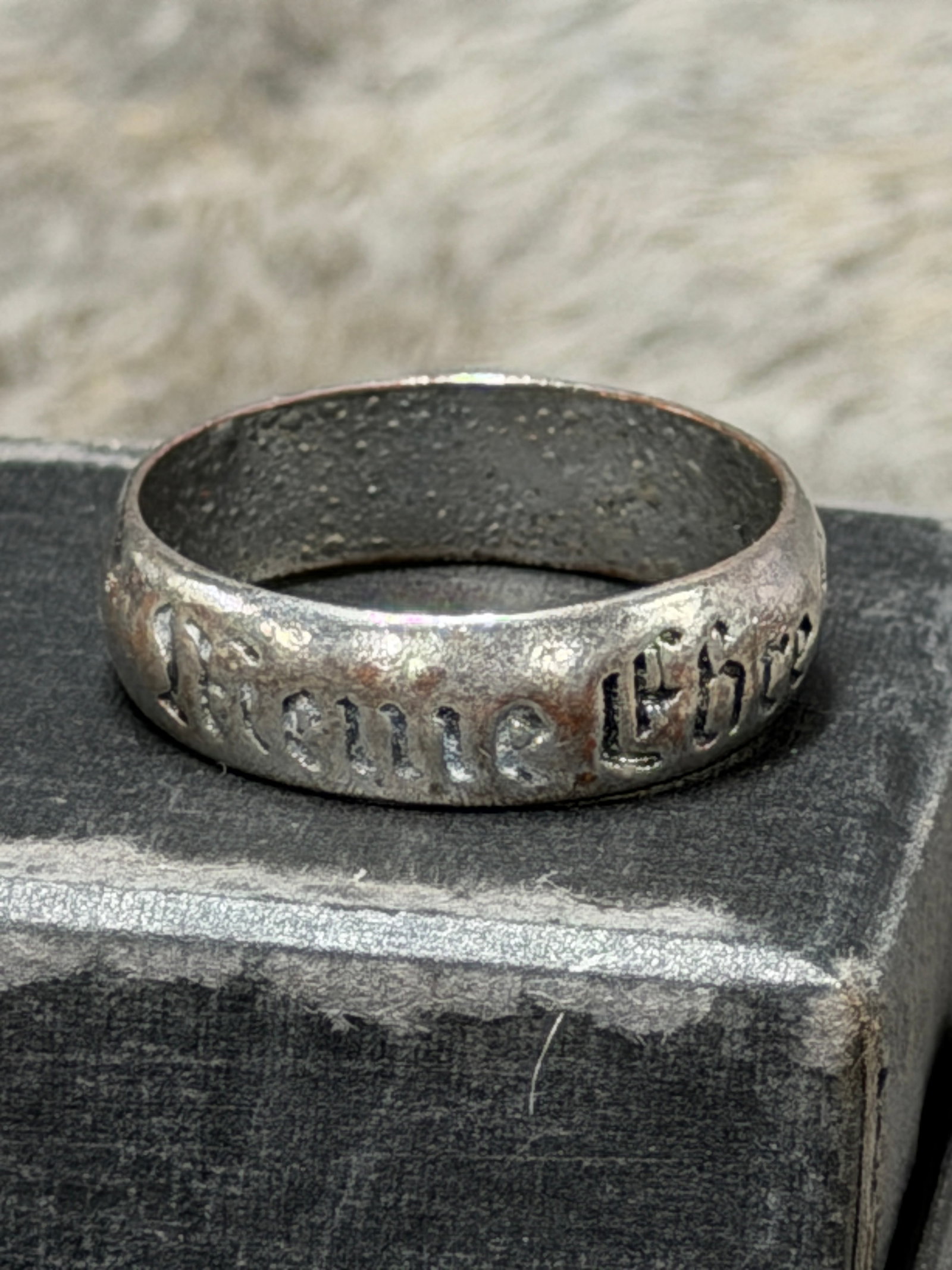 WWII German “Meine Ehre Heißt Treue?? SS Motto 925 Silver Ring: Distinctive WWII German SS-themed finger ring constructed as a broad silver-colored band and decorated around the exterior with deeply impressed Gothic-style lettering reading “Meine Ehre heißt Tre