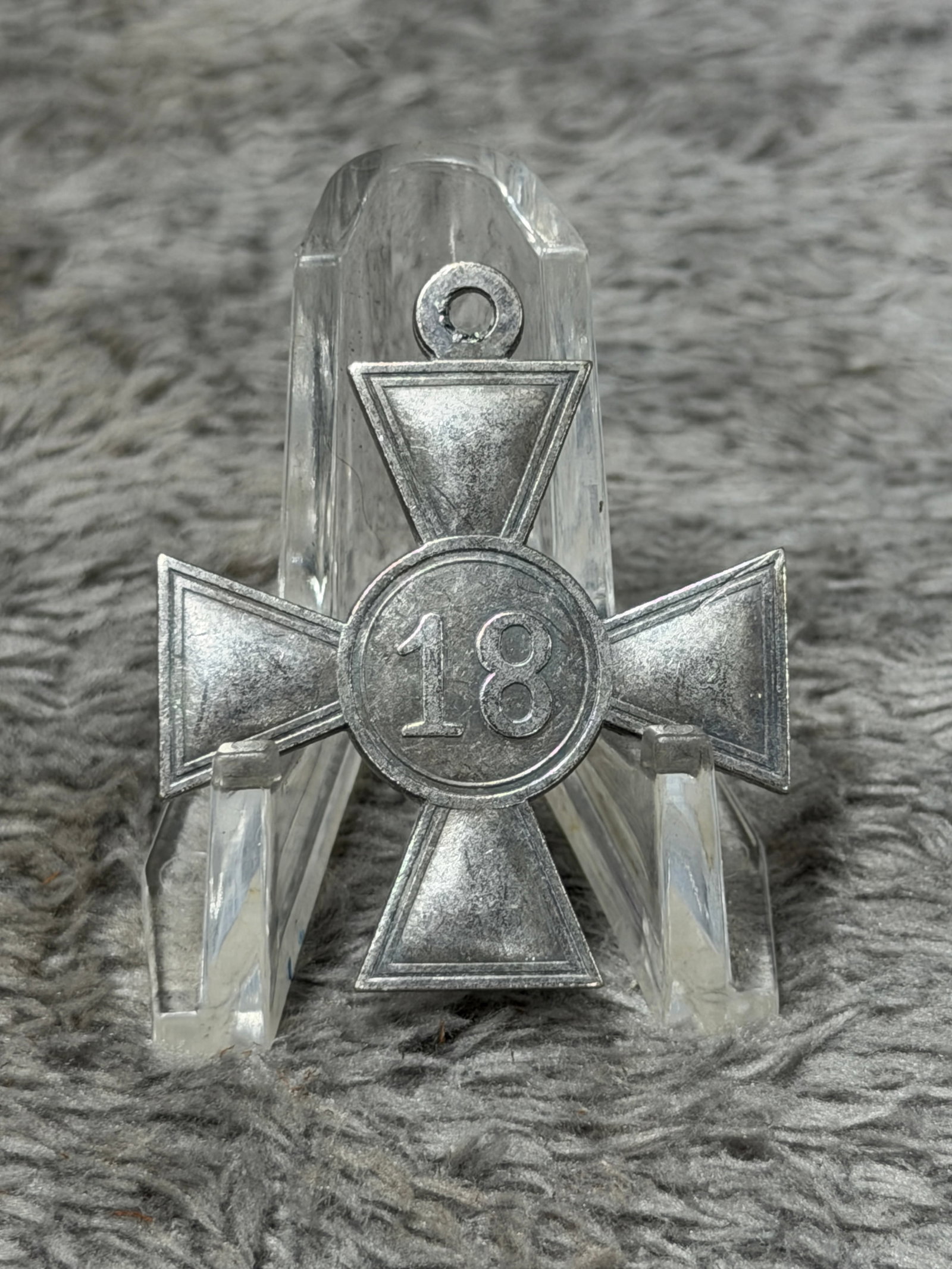WWII German 18-Year Long Service Cross with Eagle & Swastika: WWII German long-service cross featuring a traditional four-armed cross form with a circular central medallion and integral suspension eyelet. One face displays the large raised numeral “18,” 