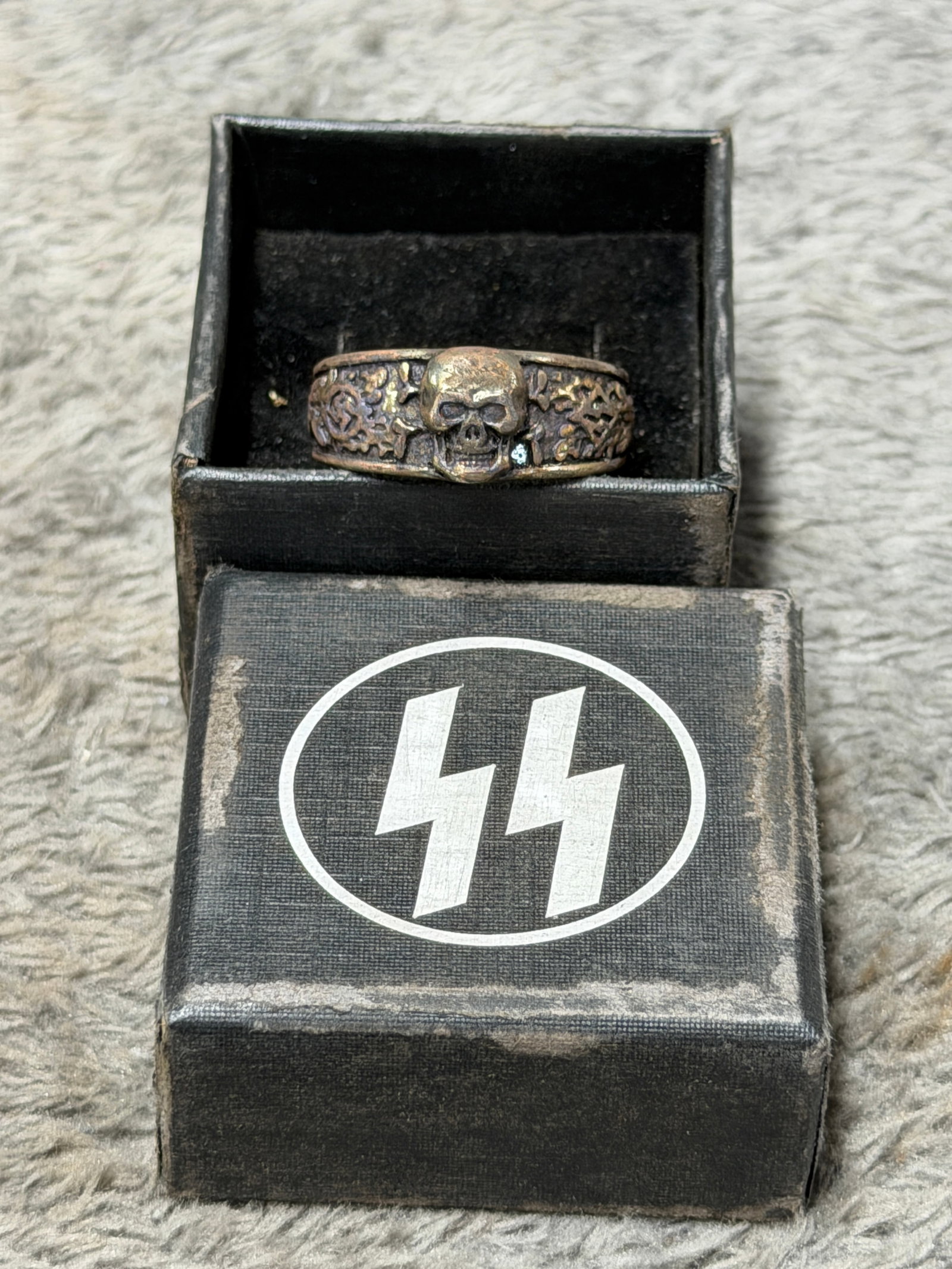 WWII German Waffen-SS Totenkopf Skull & Oak Leaf Ring with SS Presentation Box: WWII German Waffen-SS themed finger ring featuring a prominent raised Totenkopf skull as the central motif, surrounded by deeply worked oak leaves and acorns extending across the shoulders of the band