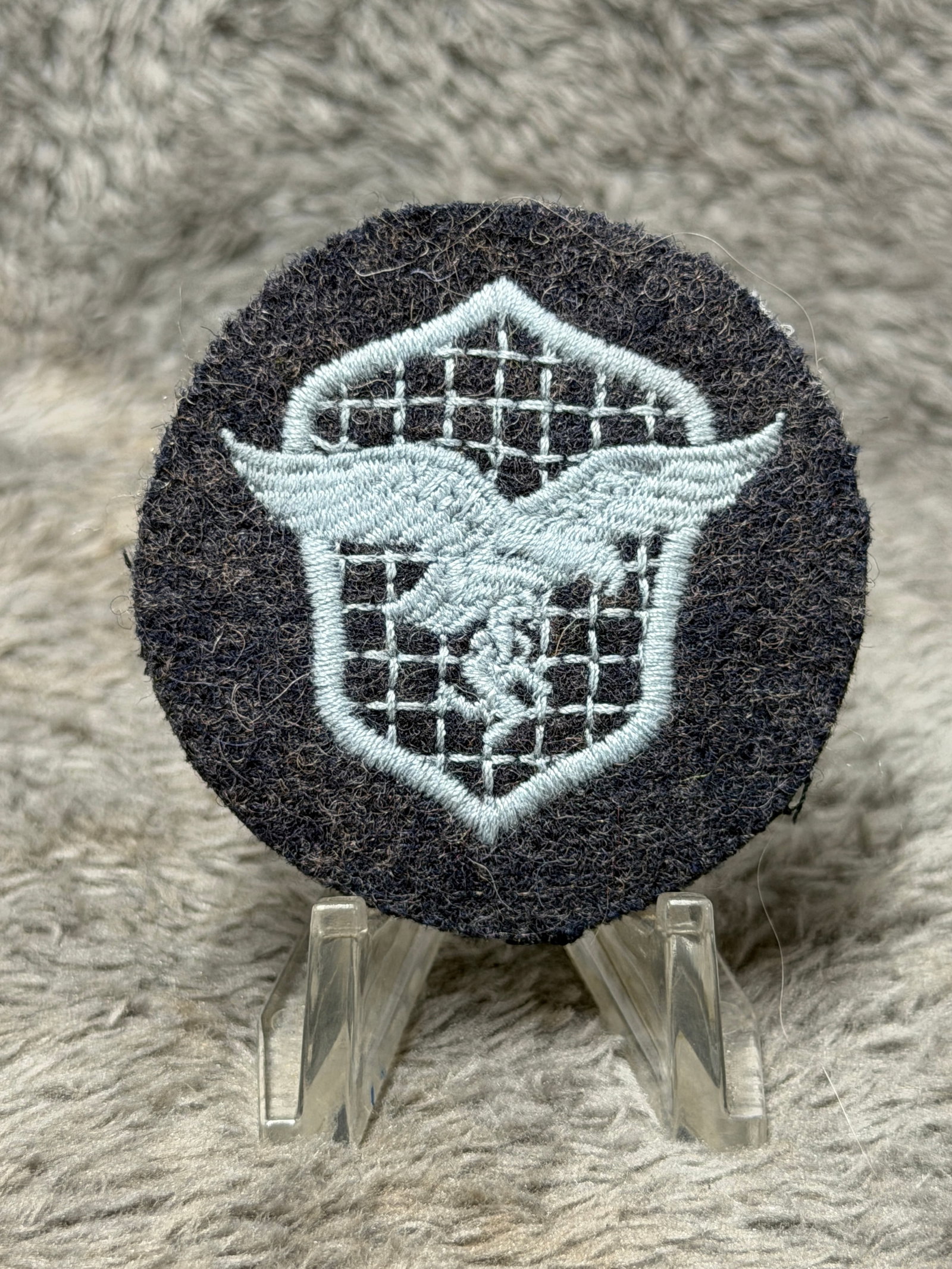 WWII German Luftwaffe Air Signals Communications Specialist Sleeve Trade Badge: WWII German Luftwaffe embroidered sleeve trade badge associated with air signals and communications personnel, constructed on a circular dark blue-gray wool field with contrasting silver-gray embroide