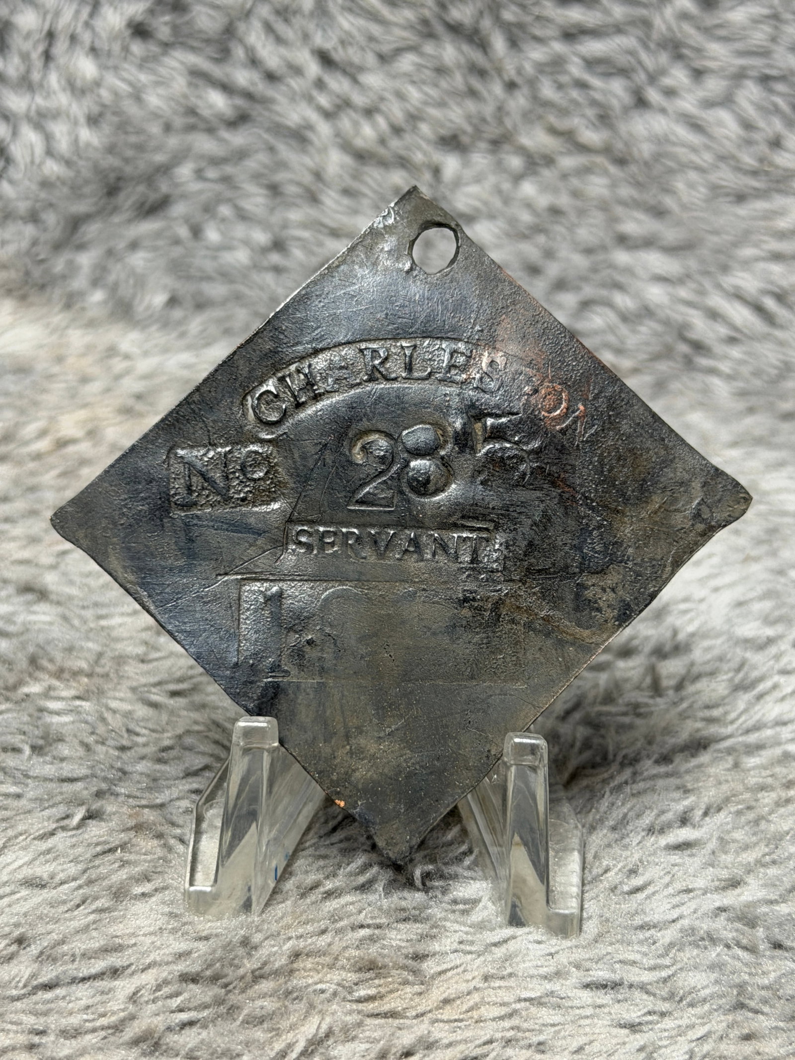 1816 Charleston No. 285 “Servant?? Slave Hire Tag – Early American Identification Badge: Historically significant 1816 Charleston slave hire tag bearing the occupational designation “SERVANT.” The metal tag is formed in the characteristic diamond shape with a pierced suspension ho