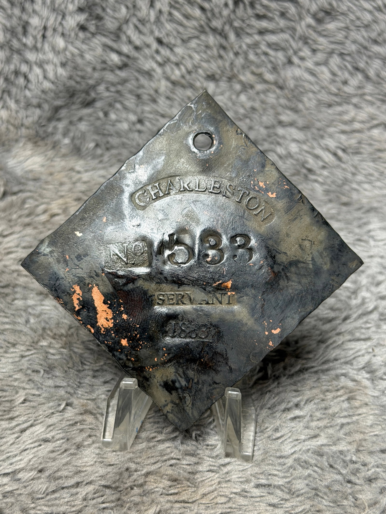 1863 Charleston No. 583 “Servant?? Slave Hire Tag – Civil War Era Identification Badge: Historically significant Civil War-era Charleston slave hire tag dated 1863, formed from a thin diamond-shaped metal plate with a pierced suspension hole near the upper point. The face is prominently 