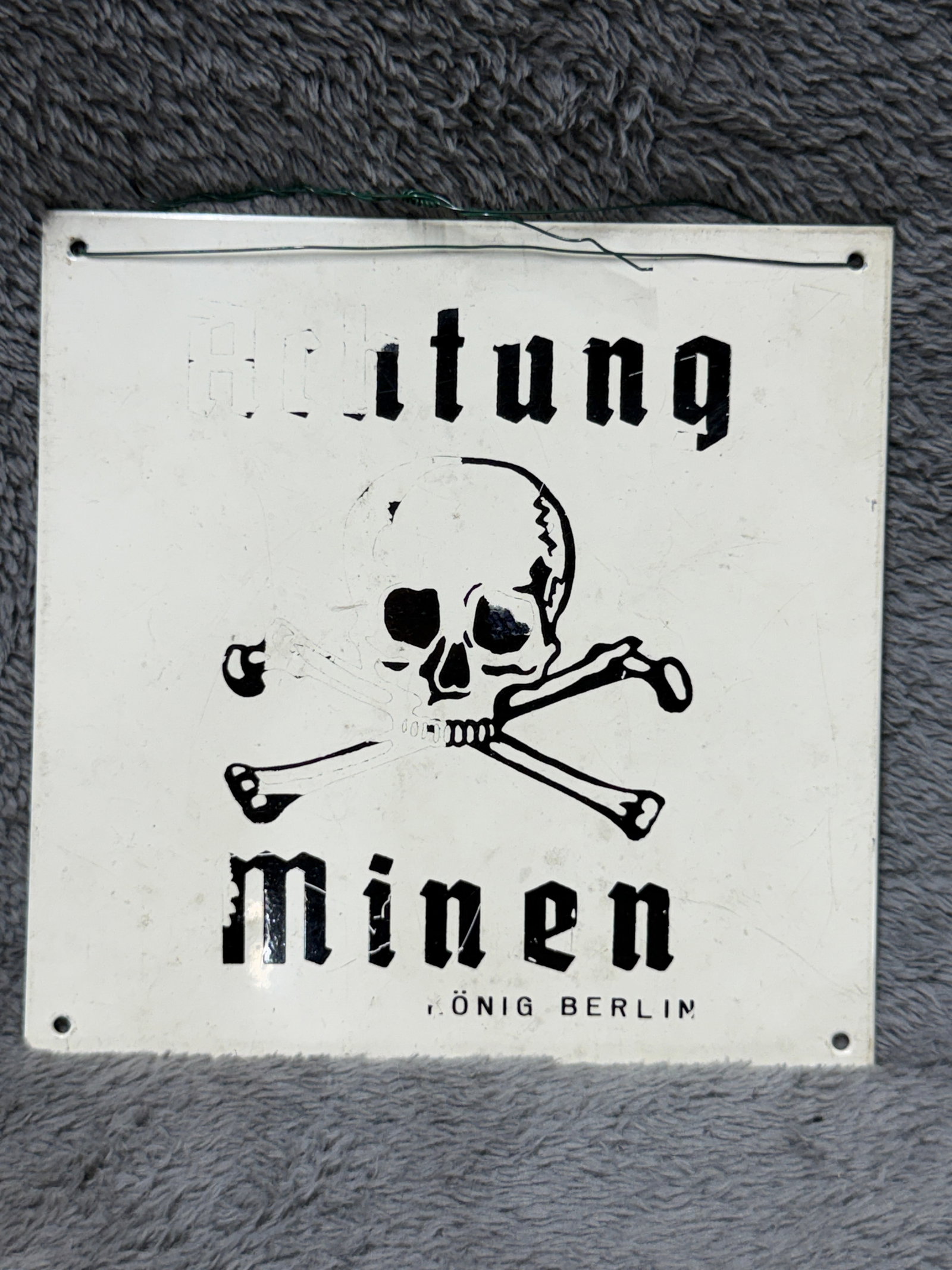 WWII German “Achtung Minen?? Skull & Crossbones Enamel Mine Warning Sign – König Berlin: WWII German “Achtung Minen” mine warning sign featuring a dramatic black skull-and-crossbones motif against a white enamel field, with bold Gothic-style lettering reading “Achtung” abo