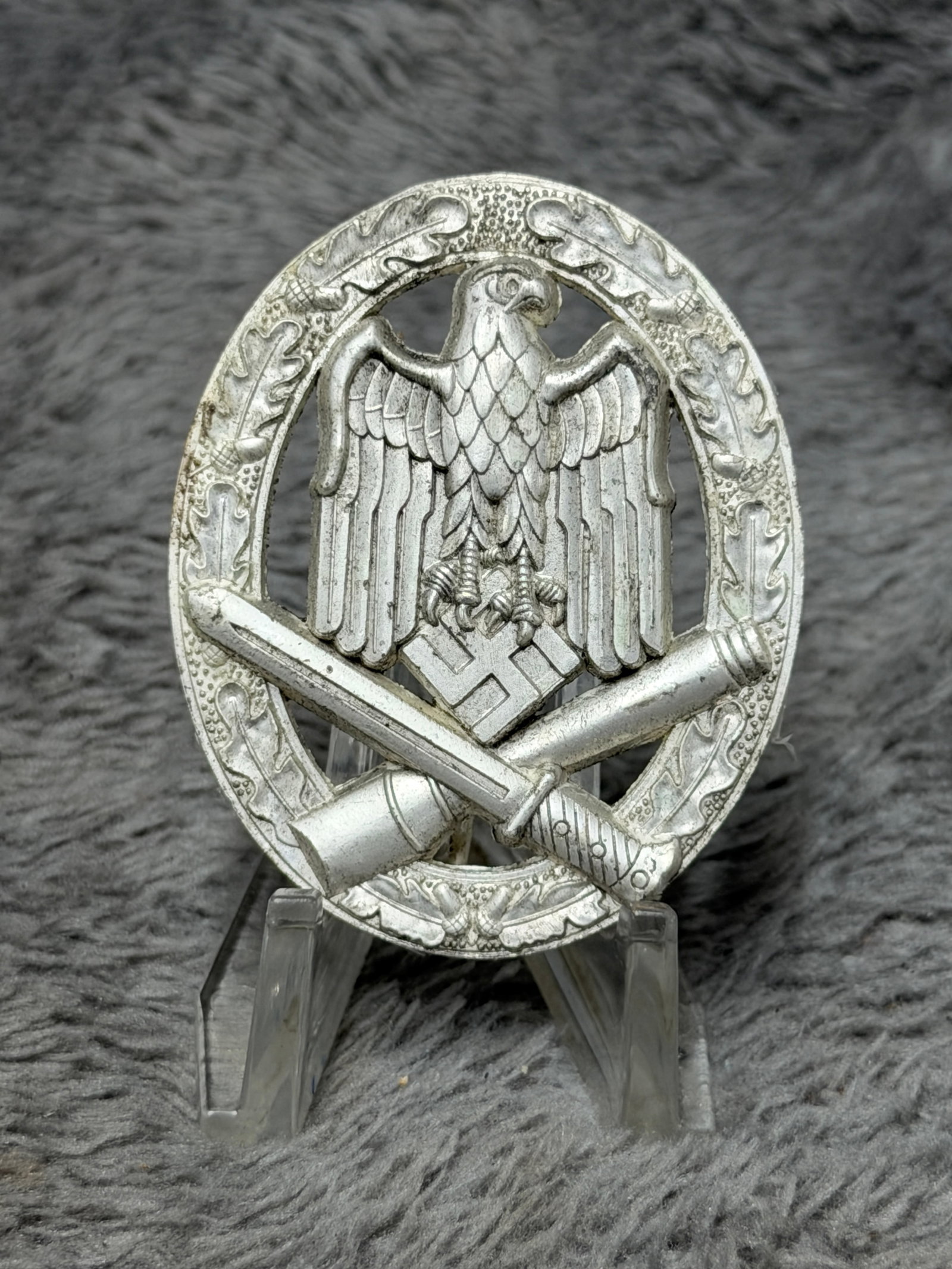 WWII German Heer General Assault Badge – JFS Maker Marked: WWII German Heer General Assault Badge featuring an oval oak-leaf wreath surrounding the prominent German military eagle and swastika, with crossed bayonet and stick grenade positioned across the lowe