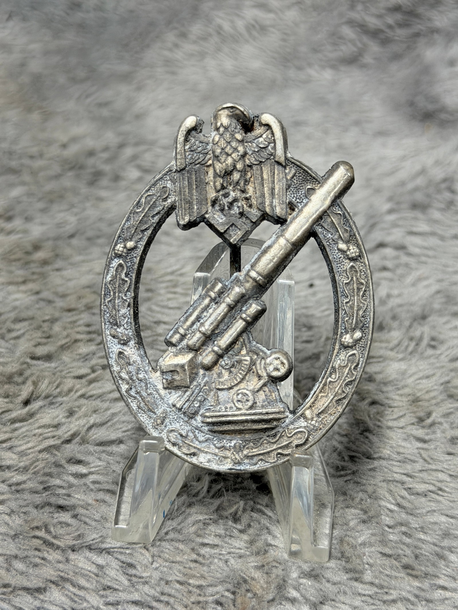 WWII German Heer Army Flak Artillery Badge – Maker Marked: WWII German Heer Army Flak Artillery Badge featuring a detailed 88mm-style anti-aircraft gun positioned diagonally within an oval oak-leaf wreath, surmounted by the German Army eagle and swastika. Ins