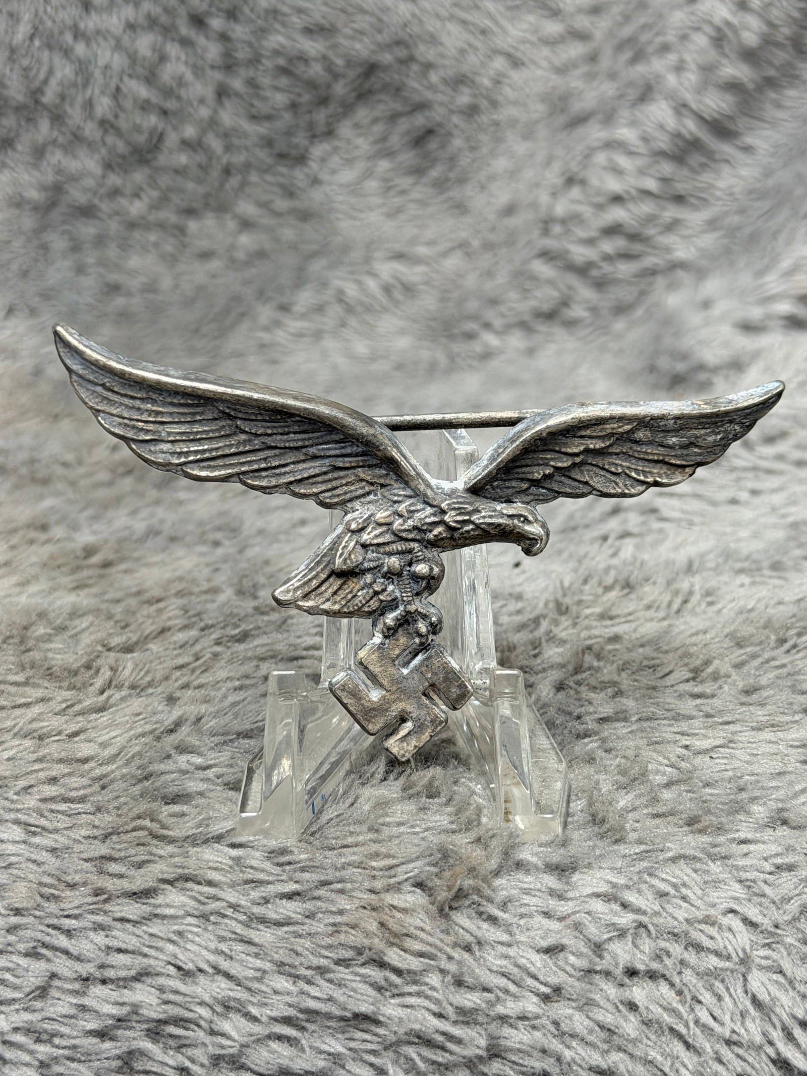 WWII German Luftwaffe Officer’s Breast Eagle Insignia – Large Metal Pin: WWII German Luftwaffe breast eagle insignia featuring the distinctive spread-wing Luftwaffe eagle clutching a swastika in its talons. The dramatic three-dimensional design displays deeply rendered win