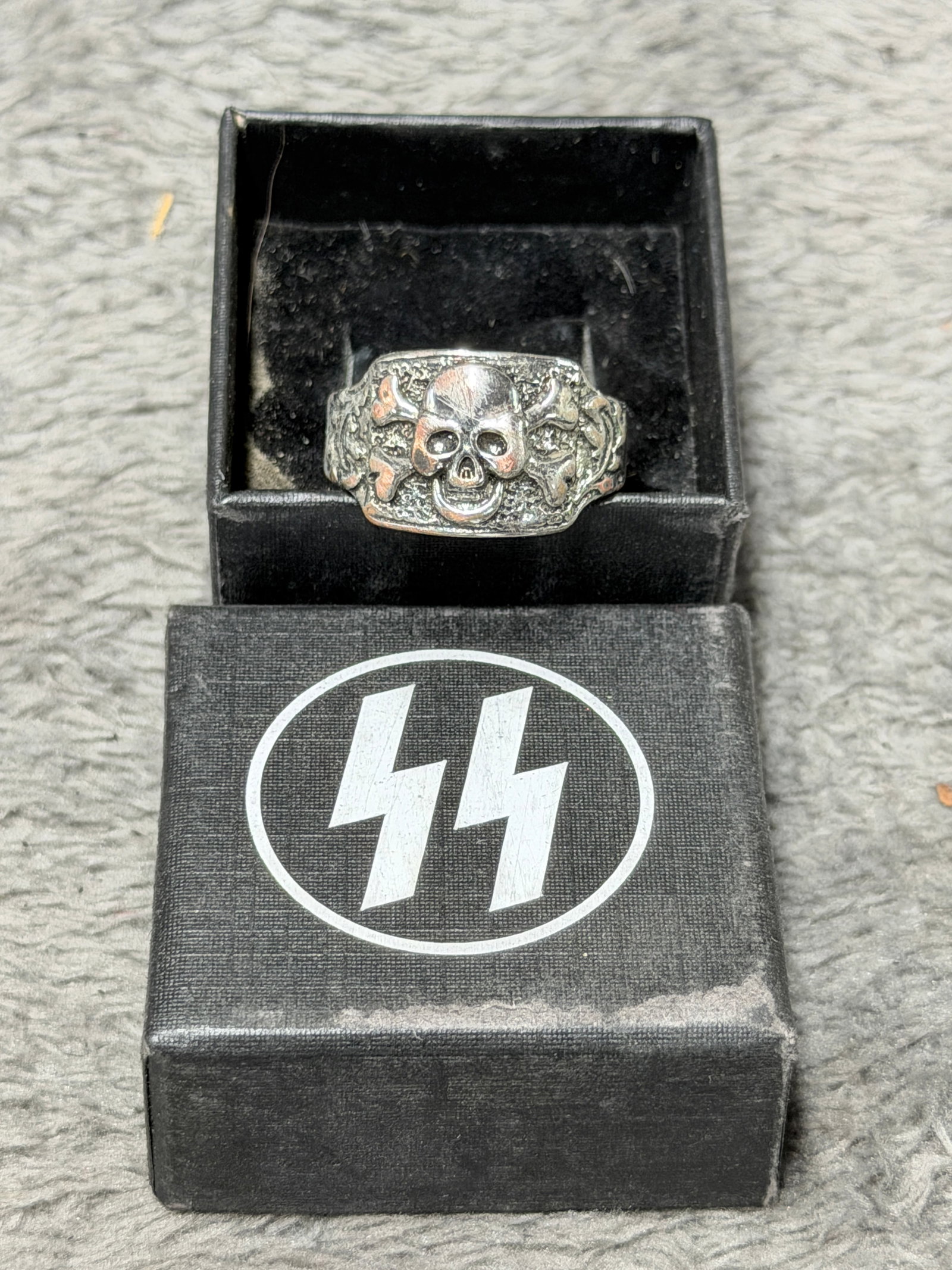 WWII German Waffen-SS Totenkopf Skull Ring Marked “900?? with Iron Cross: Striking WWII German Waffen-SS Totenkopf skull ring featuring a large raised skull-and-crossbones motif across the face, surrounded by deeply textured and ornamental relief work extending toward the s