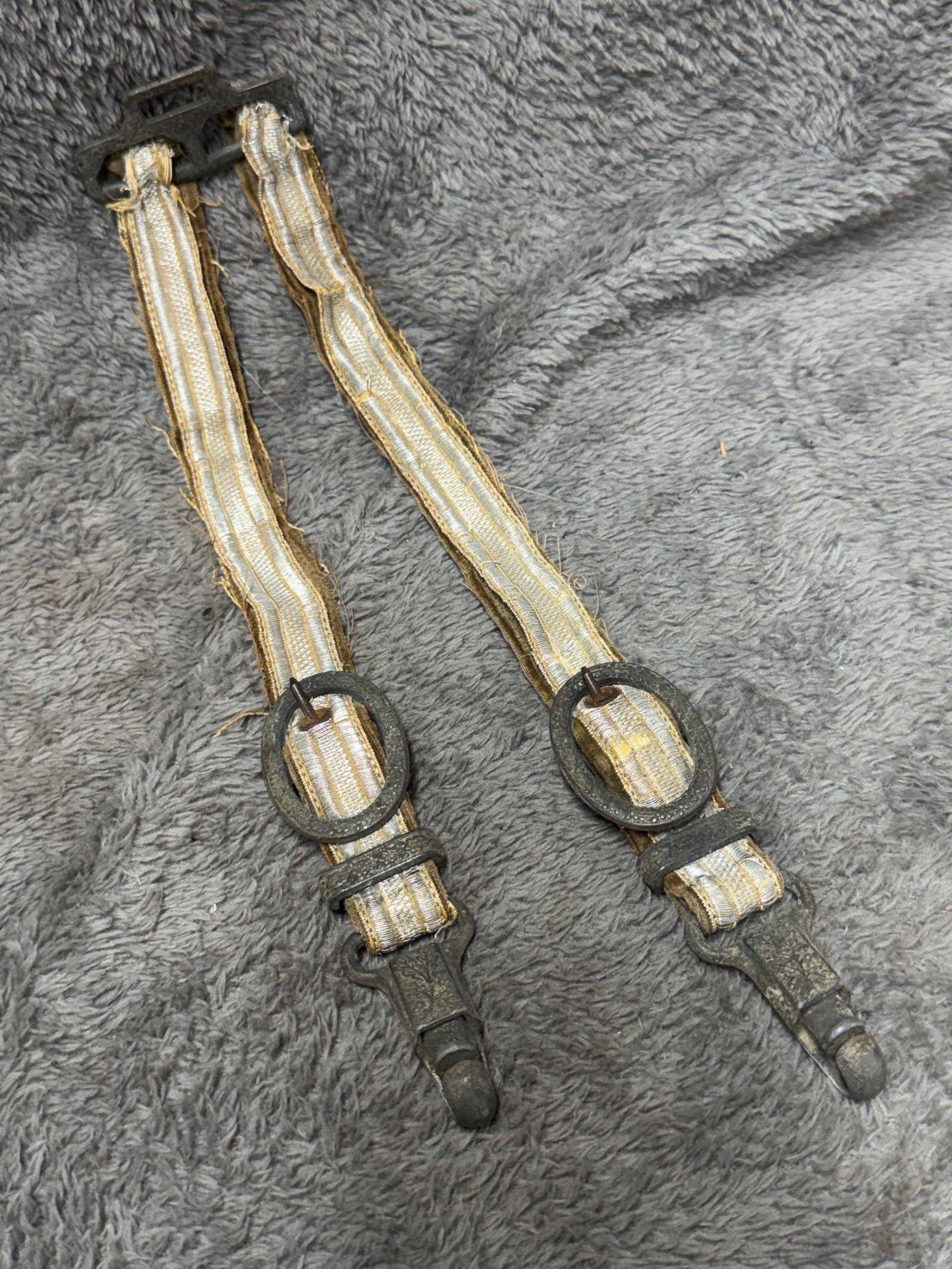 WWII German Officer’s Deluxe Silver Brocade Dress Dagger Hangers with Oak Leaf Fittings: WWII German officer’s dress dagger suspension hanger set featuring a matching pair of metallic silver brocade straps mounted to a decorative upper suspension bar. Each strap is constructed with silv