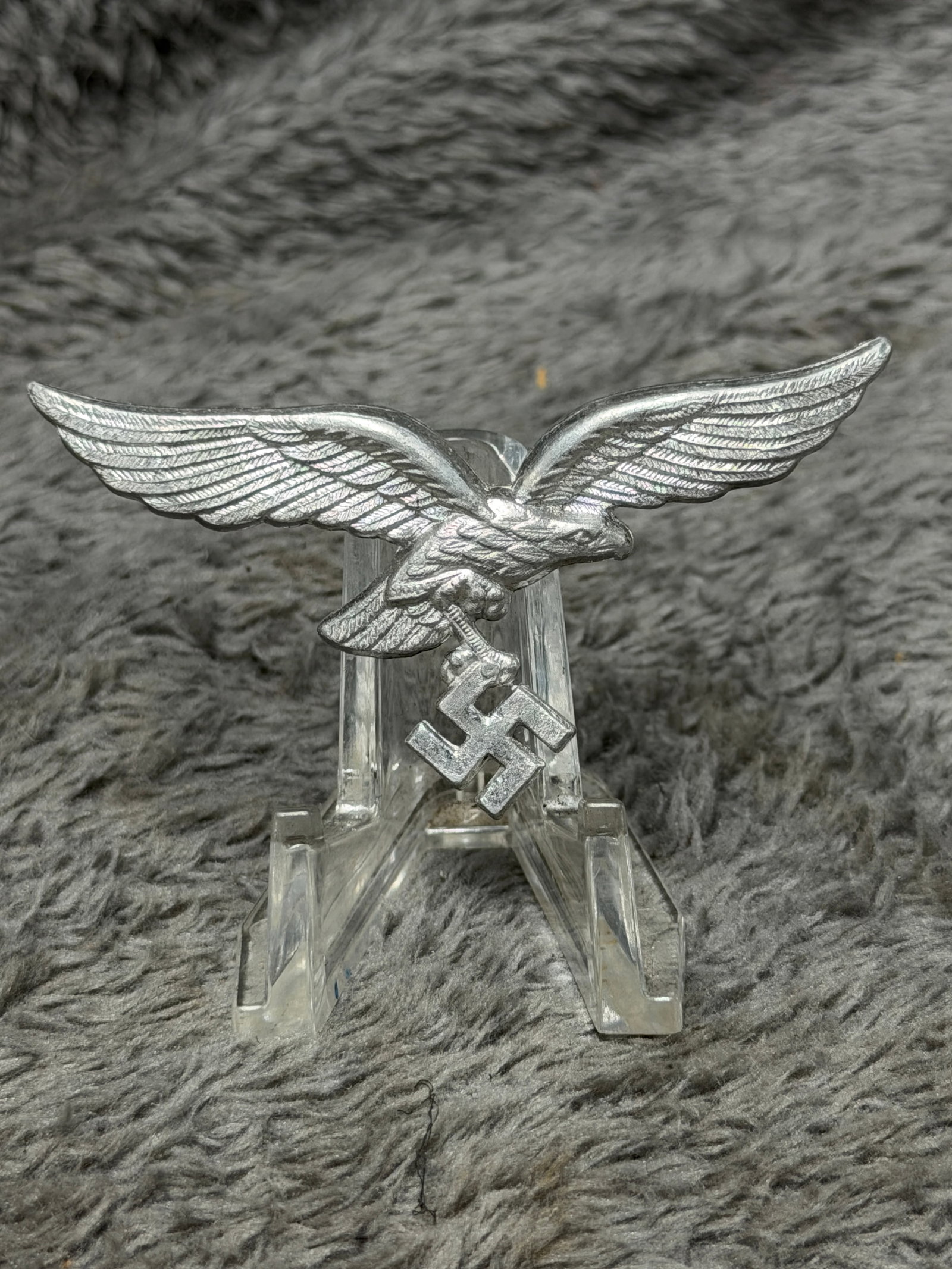 WWII German Luftwaffe Officer Metal Breast Eagle Insignia: WWII German Luftwaffe officer breast eagle insignia executed in silver-tone metal and depicting the distinctive Luftwaffe eagle in flight with outstretched wings, finely rendered feather detailing and