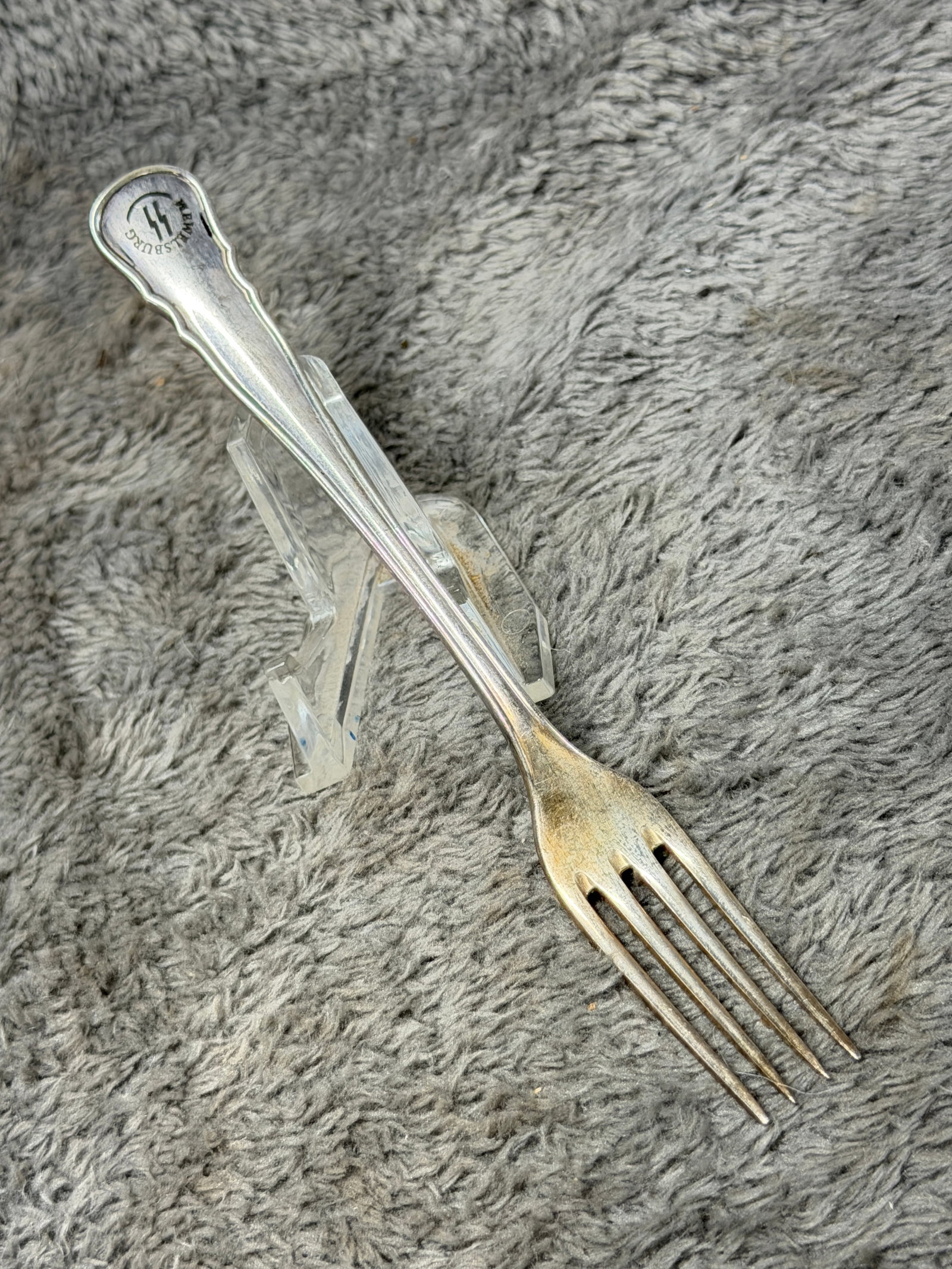 WWII German Waffen-SS Officers’ Mess Silverware Fork – SS Runes Marked: WWII German Waffen-SS officers’ mess or table-service fork featuring a traditional four-tine form with an elongated, subtly contoured handle and raised edge detailing. The terminal is prominently ma
