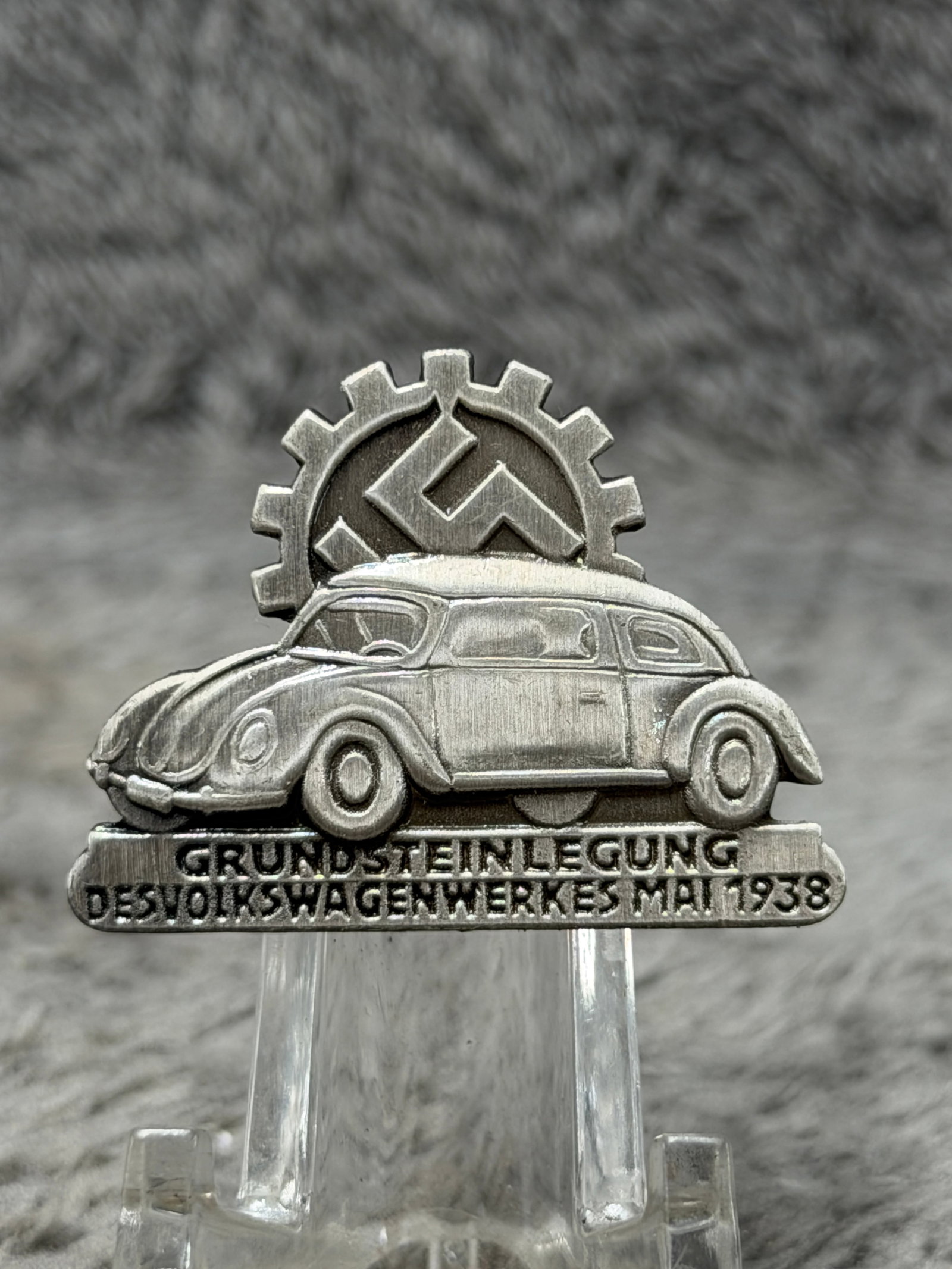 WWII German 1938 Volkswagen Factory Cornerstone Ceremony Commemorative Badge – KdF-Wagen Wolfsburg: Striking WWII German commemorative badge produced in connection with the ceremonial laying of the cornerstone for the Volkswagen factory in May 1938. The detailed relief design features an early Volks
