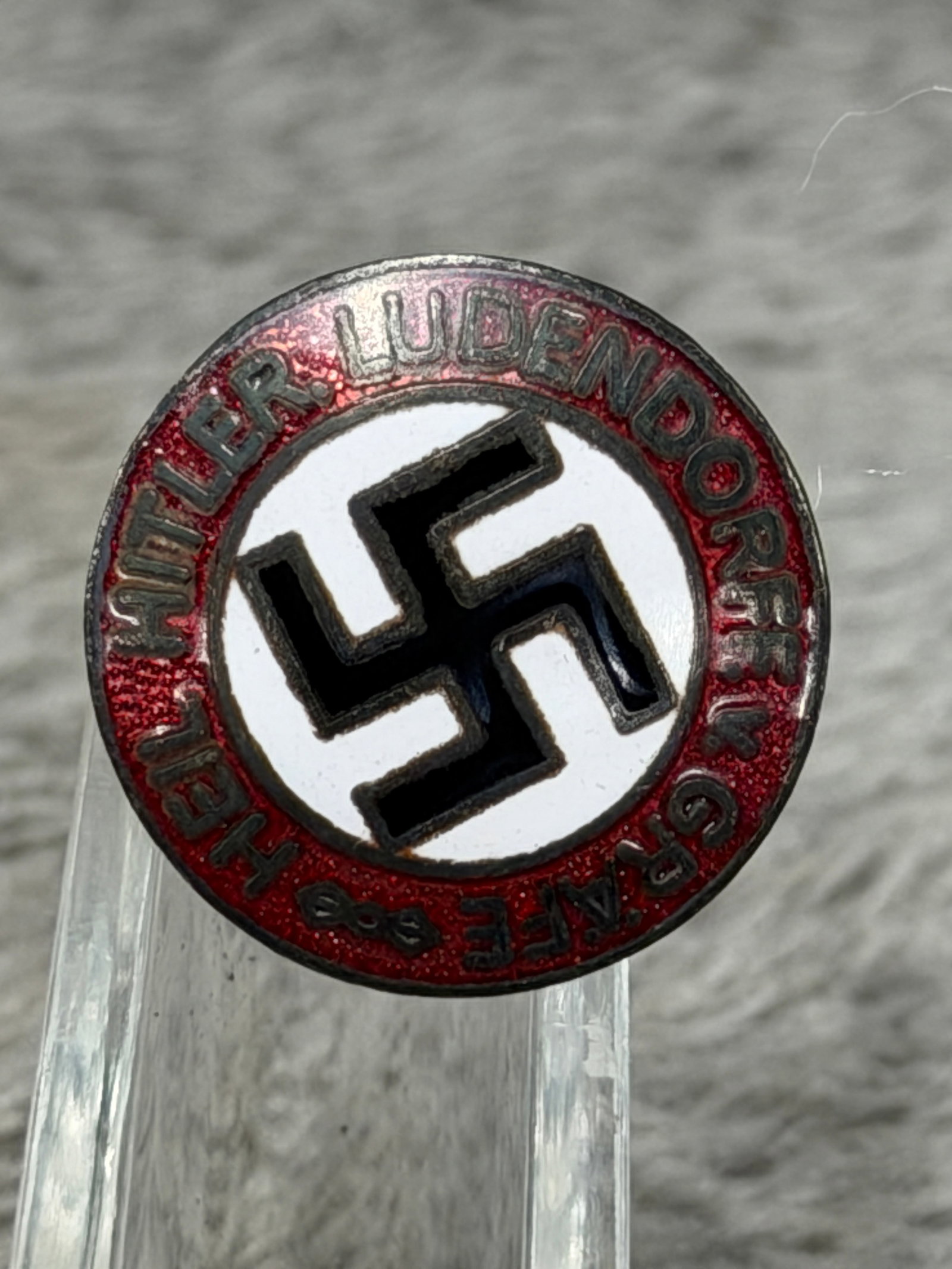 WWII German NSDAP Hitler-Ludendorff Grave 8–9 November Commemorative Enamel Badge: WWII German political commemorative enamel badge featuring a bold black swastika centered upon a white circular field and surrounded by a red enameled border bearing the inscription “HITLER-LUDENDOR