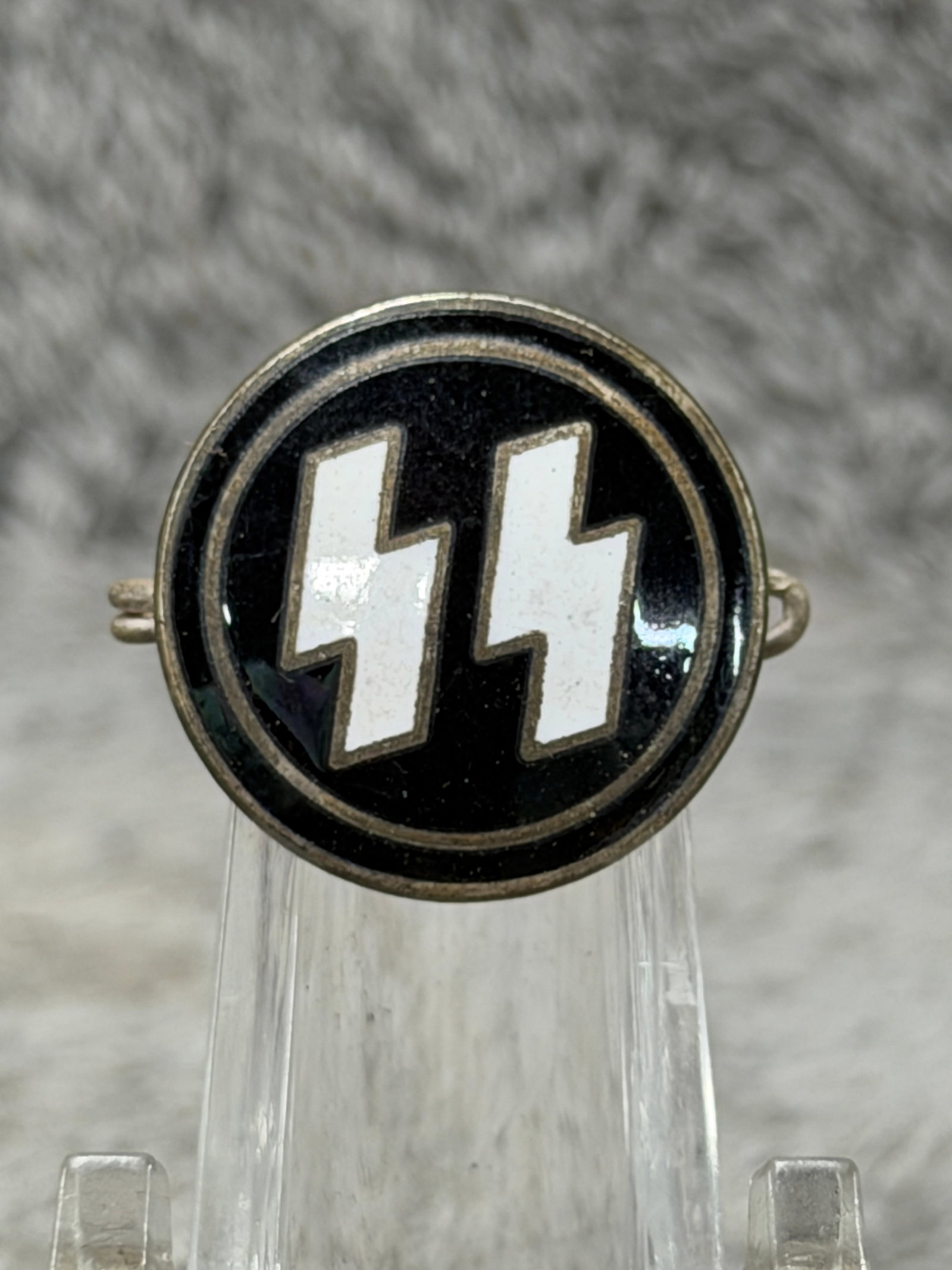 WWII German Waffen-SS RZM M1/4 Black & White Enamel Membership Badge: WWII German Waffen-SS circular enamel badge featuring the distinctive double Sig rune emblem rendered in white against a glossy black field, surrounded by concentric raised metal borders. The reverse 