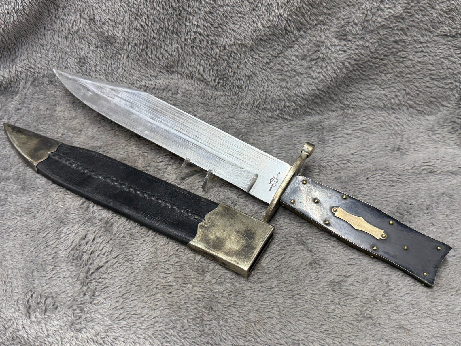 1800s Brooks & Crookes Sheffield Large Frontier Bowie Knife with Brass Mounted Sheath: Striking 1800s large frontier Bowie knife bearing the “BROOKES & CROOKES / SHEFFIELD” maker’s mark beneath a crown device at the base of the blade. The knife features an imposing broad steel