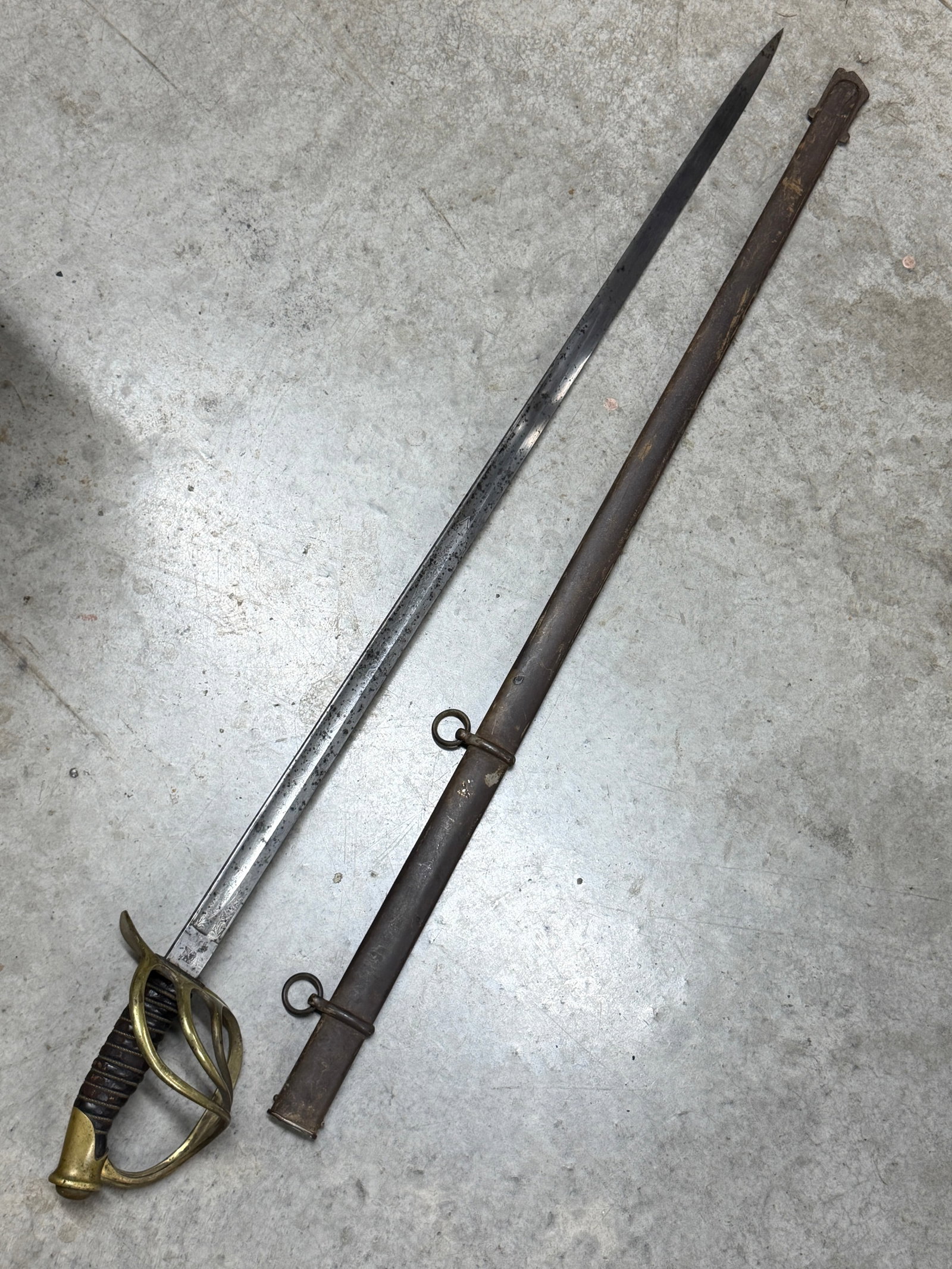 Civil War U.S. Cavalry Officer Presentation Sword with Etched Blade, Brass Guard & Scabbard: Striking Civil War-era U.S. cavalry officer sword featuring an exceptionally long, slightly curved steel blade with extensive decorative etching, a substantial brass multi-branch hand guard, leather-c