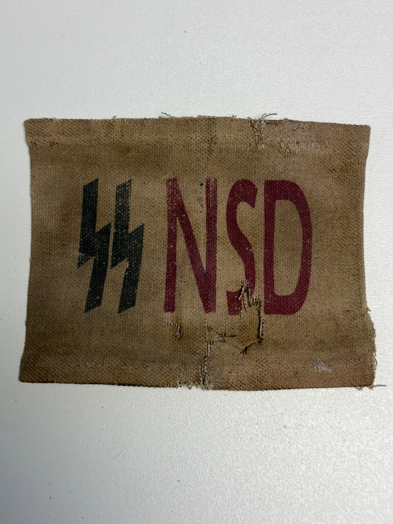 WWII German Waffen-SS NSD Marked Cloth Armband / Identification Band: WWII German Waffen-SS associated cloth identification armband constructed from tan-brown woven fabric and displaying a prominent black SS runic emblem alongside large dark red “NSD” lettering 