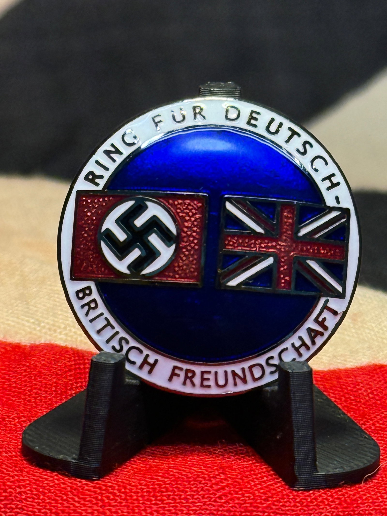 WWII German-British Friendship “Ring für Deutsch-Britische Freundschaft?? Enamel Badge By: A striking circular enamel badge bearing the German inscription “RING FÜR DEUTSCH-BRITISCHE FREUNDSCHAFT”, translating to “Circle for German-British Friendship.” The face displays the