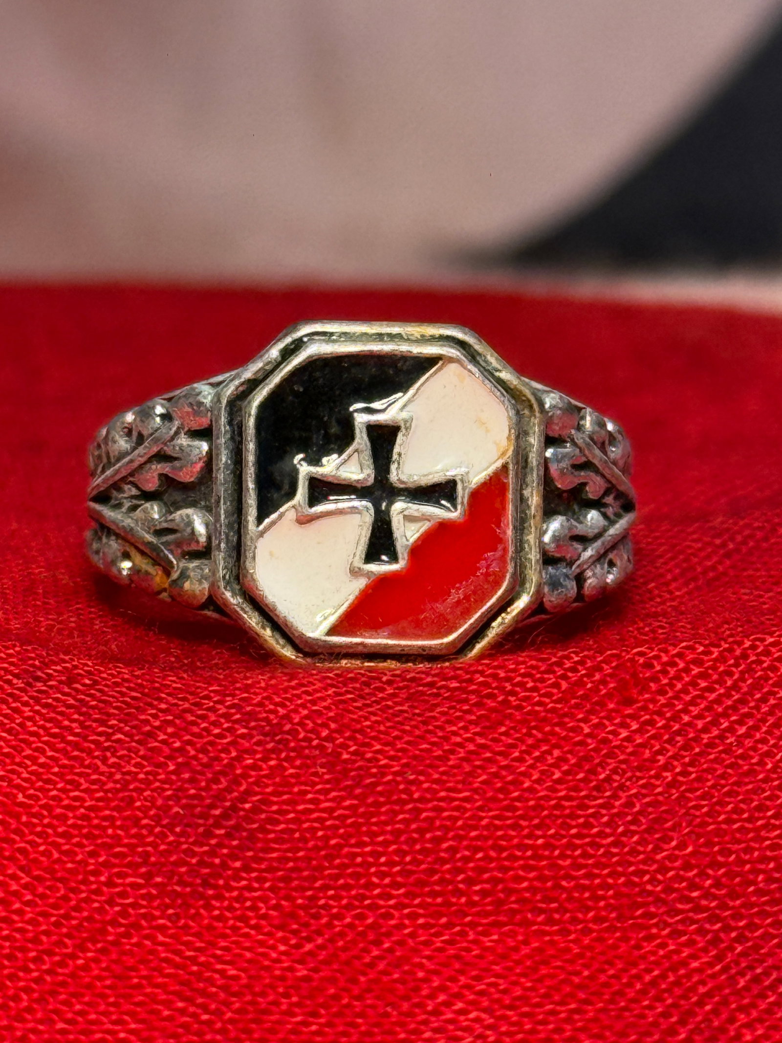 WWII German Iron Cross Patriotic 835 Silver Enamel Ring: A substantial German silver ring featuring an octagonal face decorated with a central black Iron Cross surrounded by contrasting black, white, and red enamel fields. Both shoulders are heavily decorat