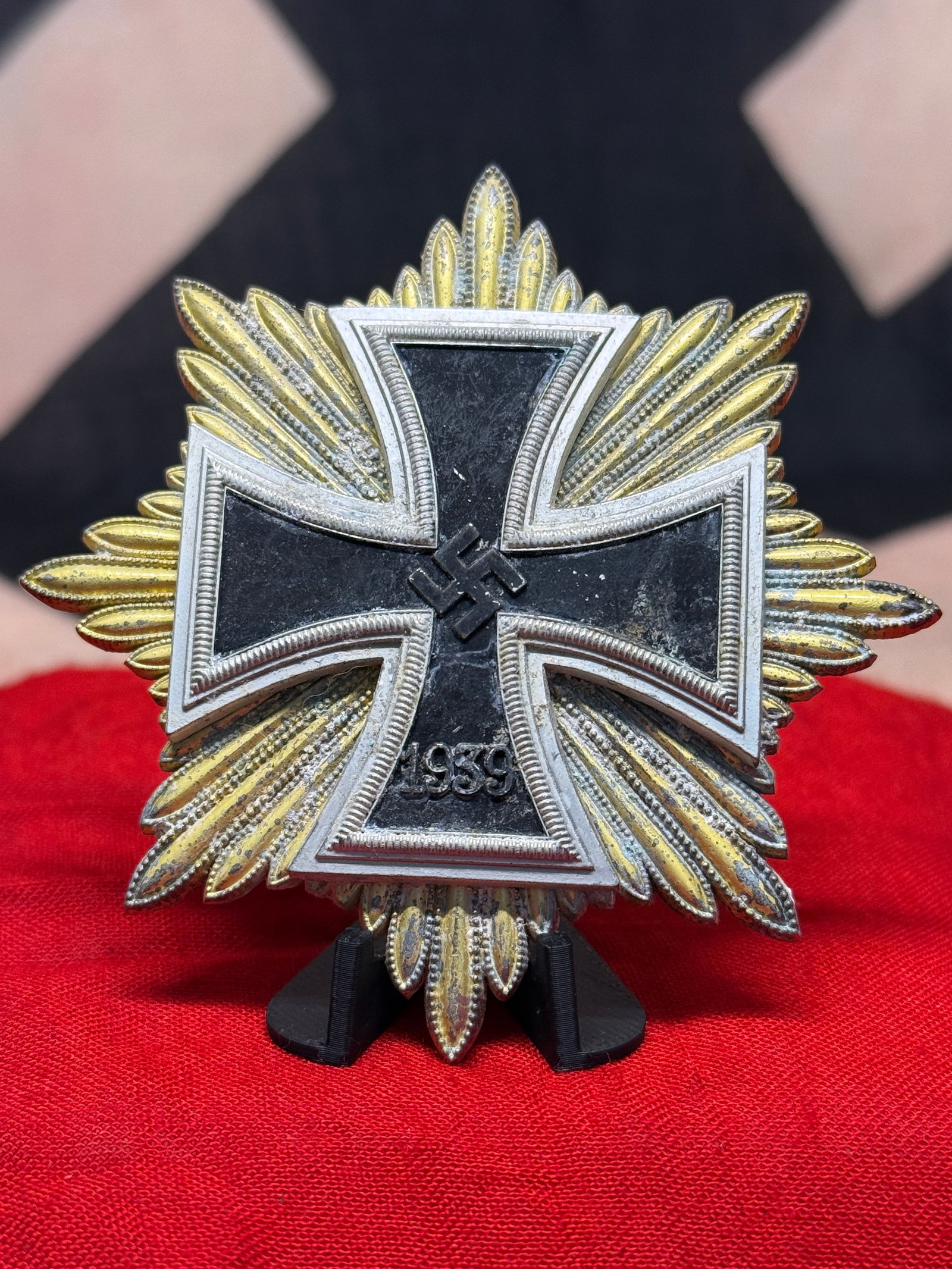WWII German 1939 Iron Cross Starburst Breast Badge: Imposing WWII German breast badge featuring a large multi-rayed starburst surrounding a centrally mounted 1939 Iron Cross. The cross displays a blackened center with silver-colored borders, a central 