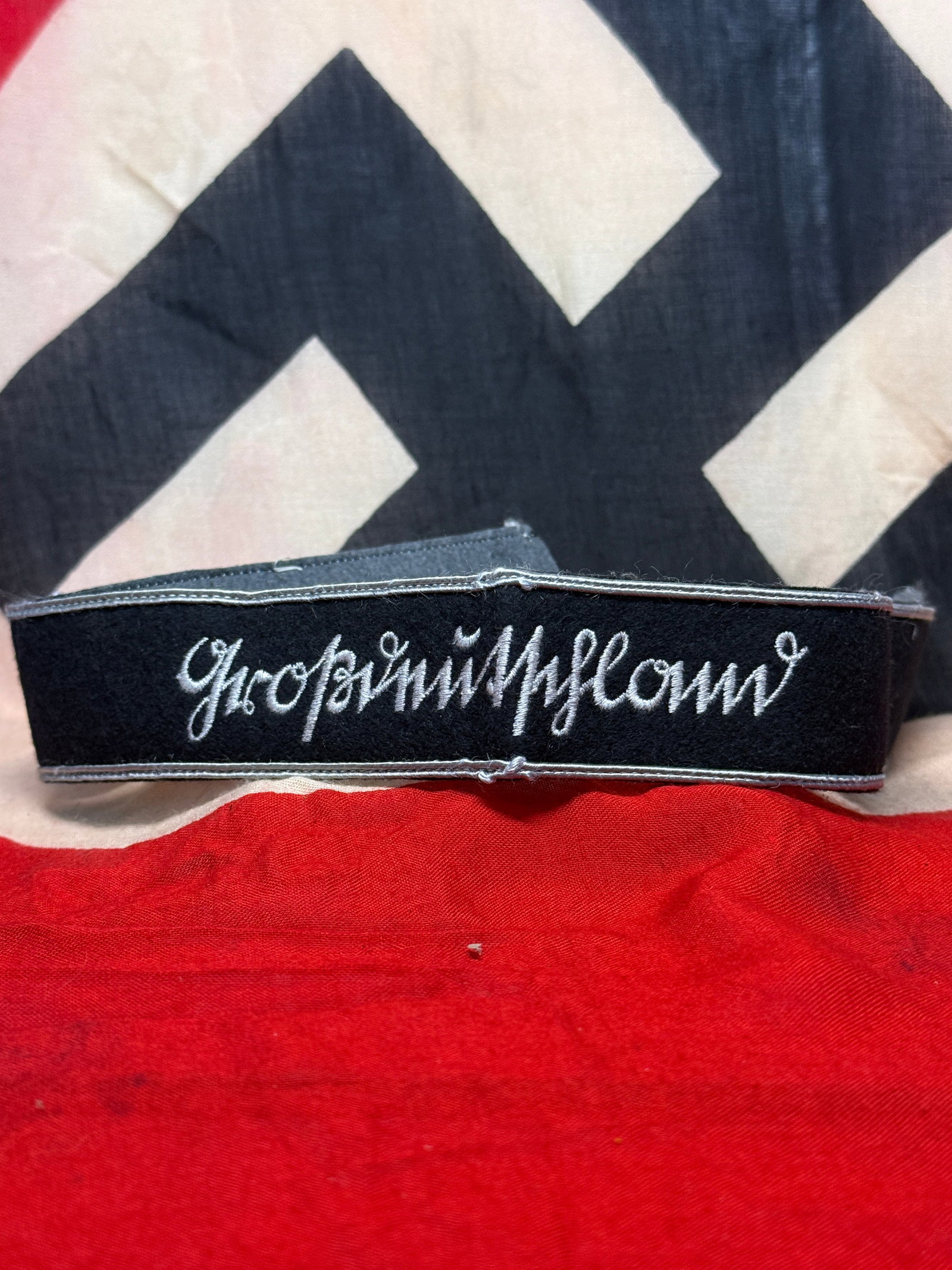 WWII German Waffen-SS “Großdeutschland?? BeVo-Style Cuff Title: A black cloth cuff title featuring the Gothic-script inscription “Großdeutschland” embroidered in contrasting light-colored thread, bordered along the upper and lower edges by narrow silver-c