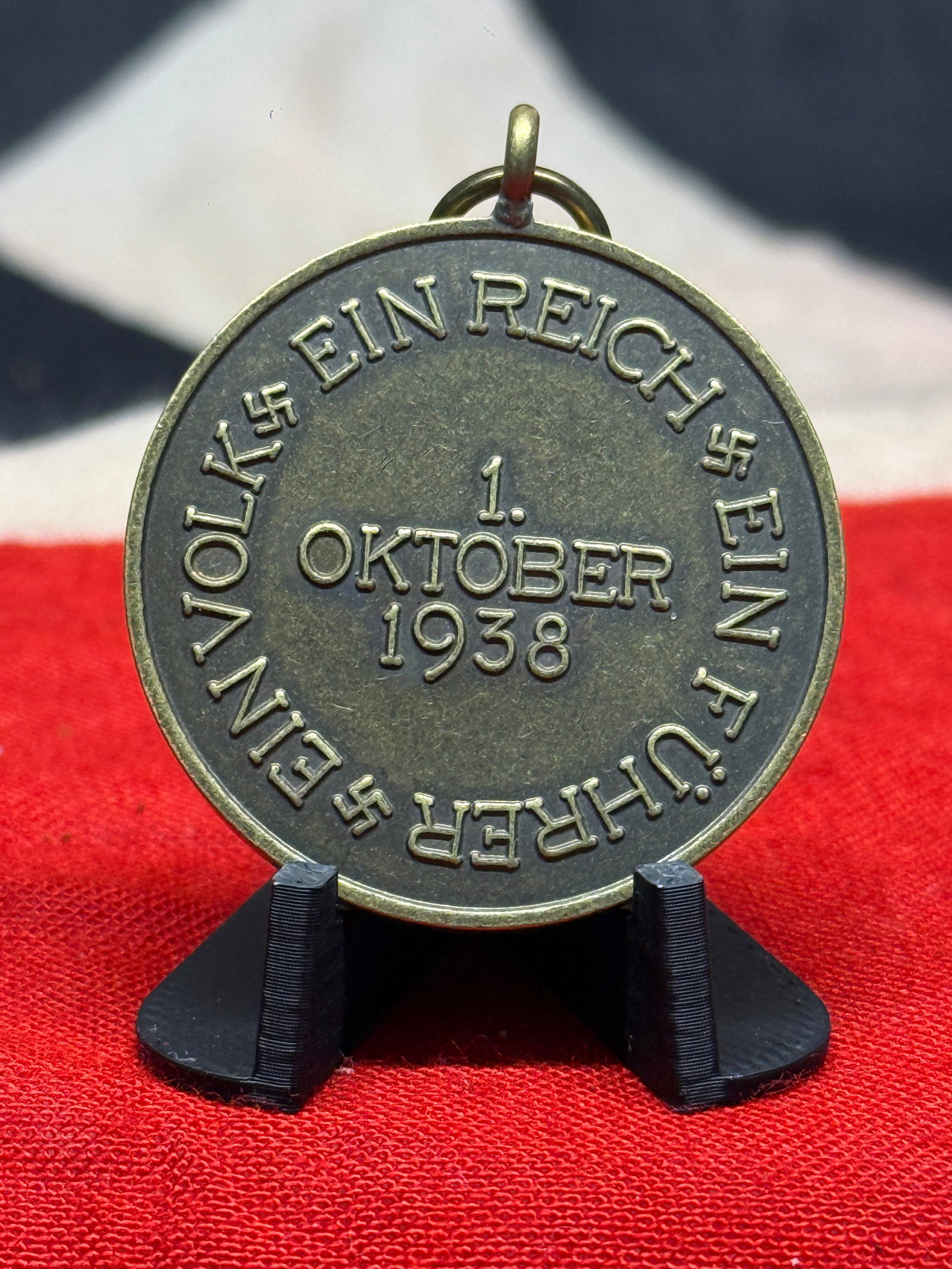 WWII German 1938 Sudetenland Annexation Commemorative Medal – “Ein Volk, Ein Reich, Ein: This circular WWII German commemorative medal is dated 1. Oktober 1938 and bears the surrounding inscription “EIN VOLK • EIN REICH • EIN FÜHRER,” translating as “One People, One R