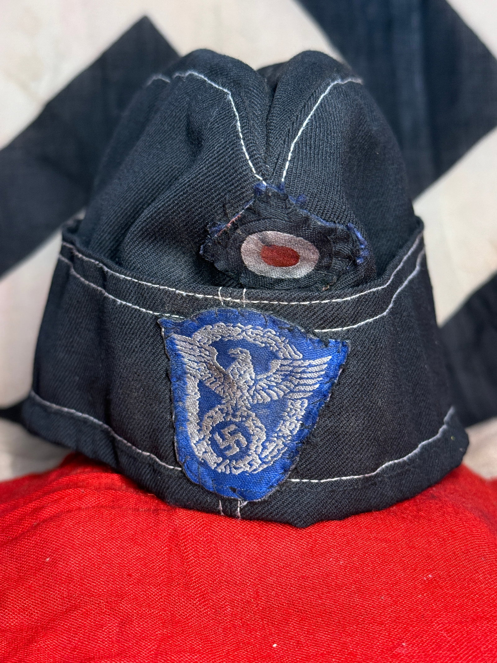 WWII German Water Protection Police Wasserschutzpolizei Overseas Side Cap with Blue Eagle Insignia: WWII German Water Protection Police (Wasserschutzpolizei) overseas side cap constructed from dark blue cloth with contrasting light-colored stitching outlining the crown, side panels and turn-up. The 