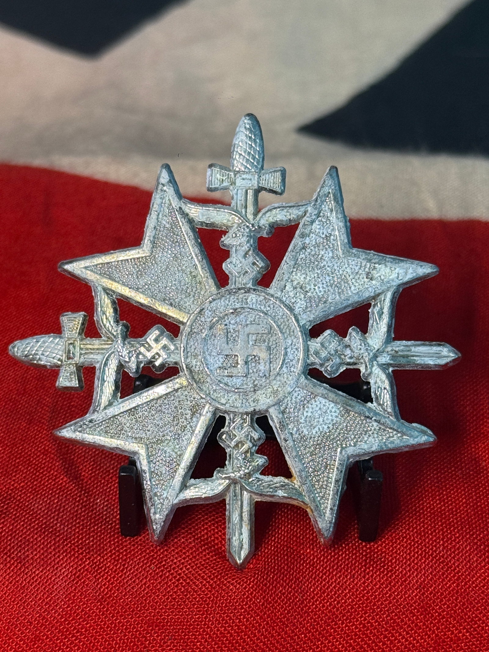 WWII German Military Cross with Swords, Eagles & Swastika Pin-Back Decoration: This elaborate silver-colored German military decoration features a broad multi-pointed cross surrounded by an unusually complex arrangement of crossed swords and German national eagles. At the center