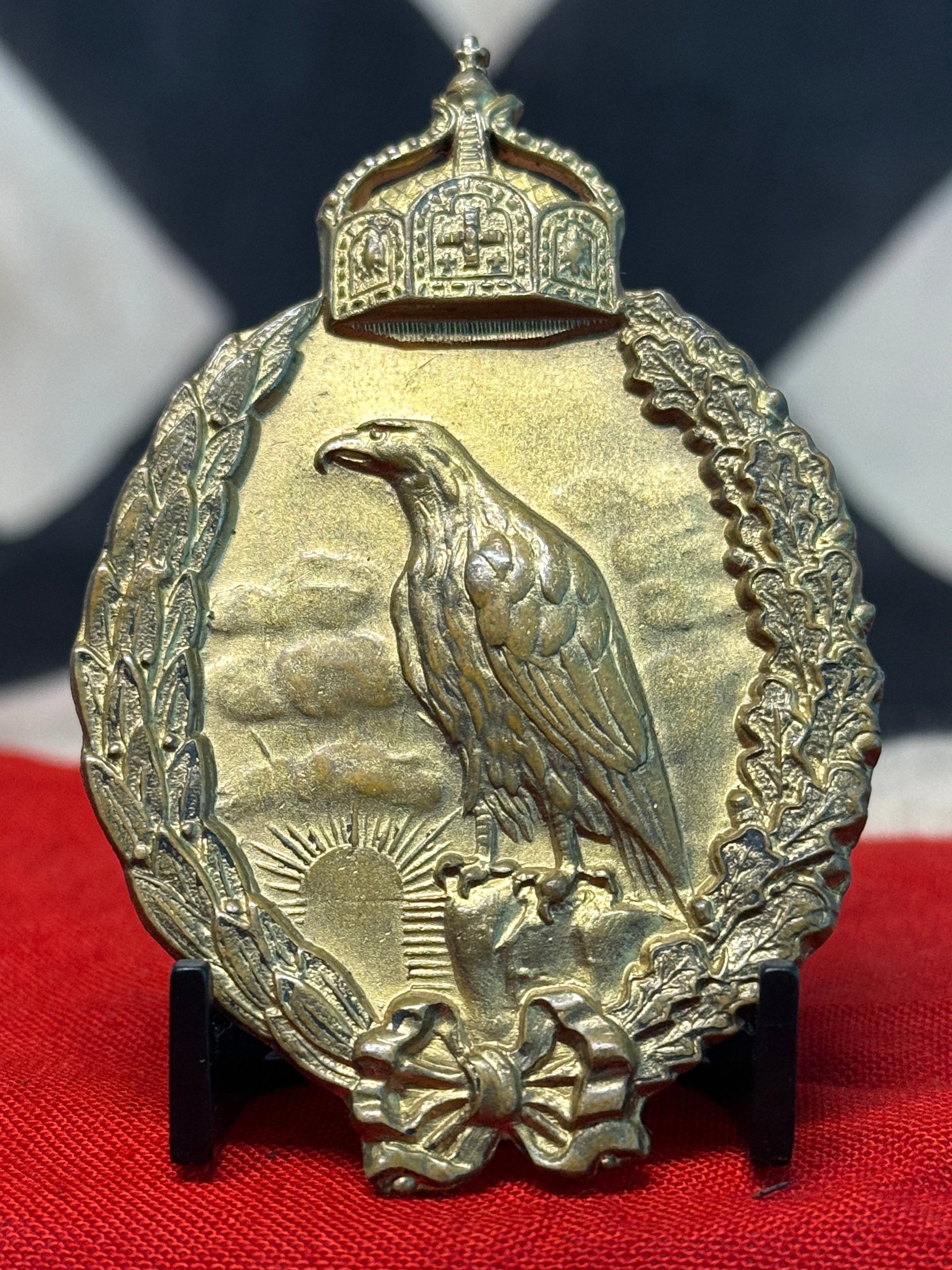Imperial German Eagle & Pickelhaube Shooting Association Badge: An elaborate gold-colored German shooting or veterans’ association badge dominated by a finely rendered Imperial eagle standing upon a raised geographic or rocky formation. A radiant rising sun appe
