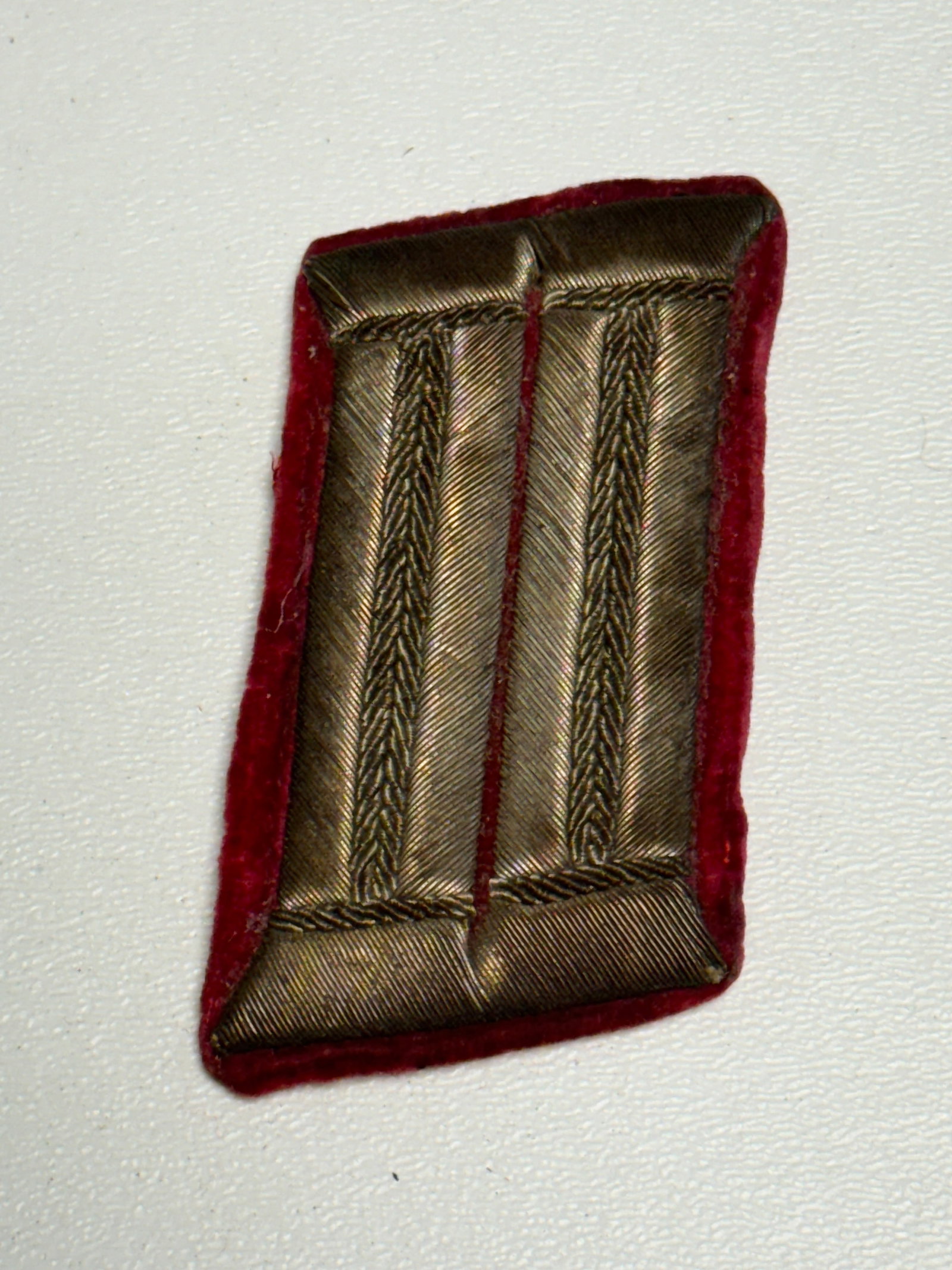 WWII German Army Artillery Officer Bullion Collar Tab Insignia: WWII German military officer’s collar tab featuring metallic bullion construction over a rich red wool backing, a branch color traditionally associated with artillery within the German Army. The fac