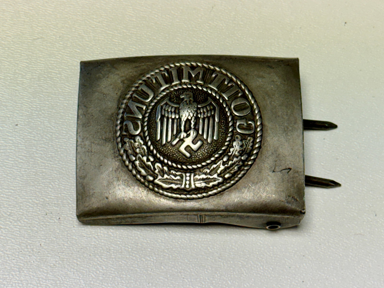 WWII German Army Heer “Gott Mit Uns?? Enlisted Belt Buckle with Eagle & Swastika: WWII German Army Heer enlisted man’s metal belt buckle featuring the raised Wehrmacht eagle and swastika at center, surrounded by the traditional military motto “GOTT MIT UNS” and an oak-lea
