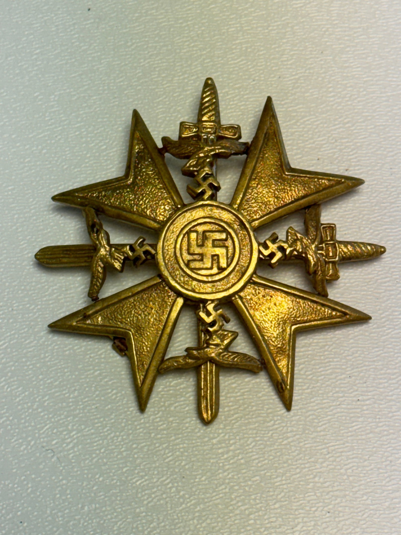 WWII German Luftwaffe Multi-Branch Combat Service Badge with Swords: Striking WWII German military badge featuring a large four-pointed star configuration centered by a circular swastika emblem and surrounded by an elaborate arrangement of crossed swords and multiple L