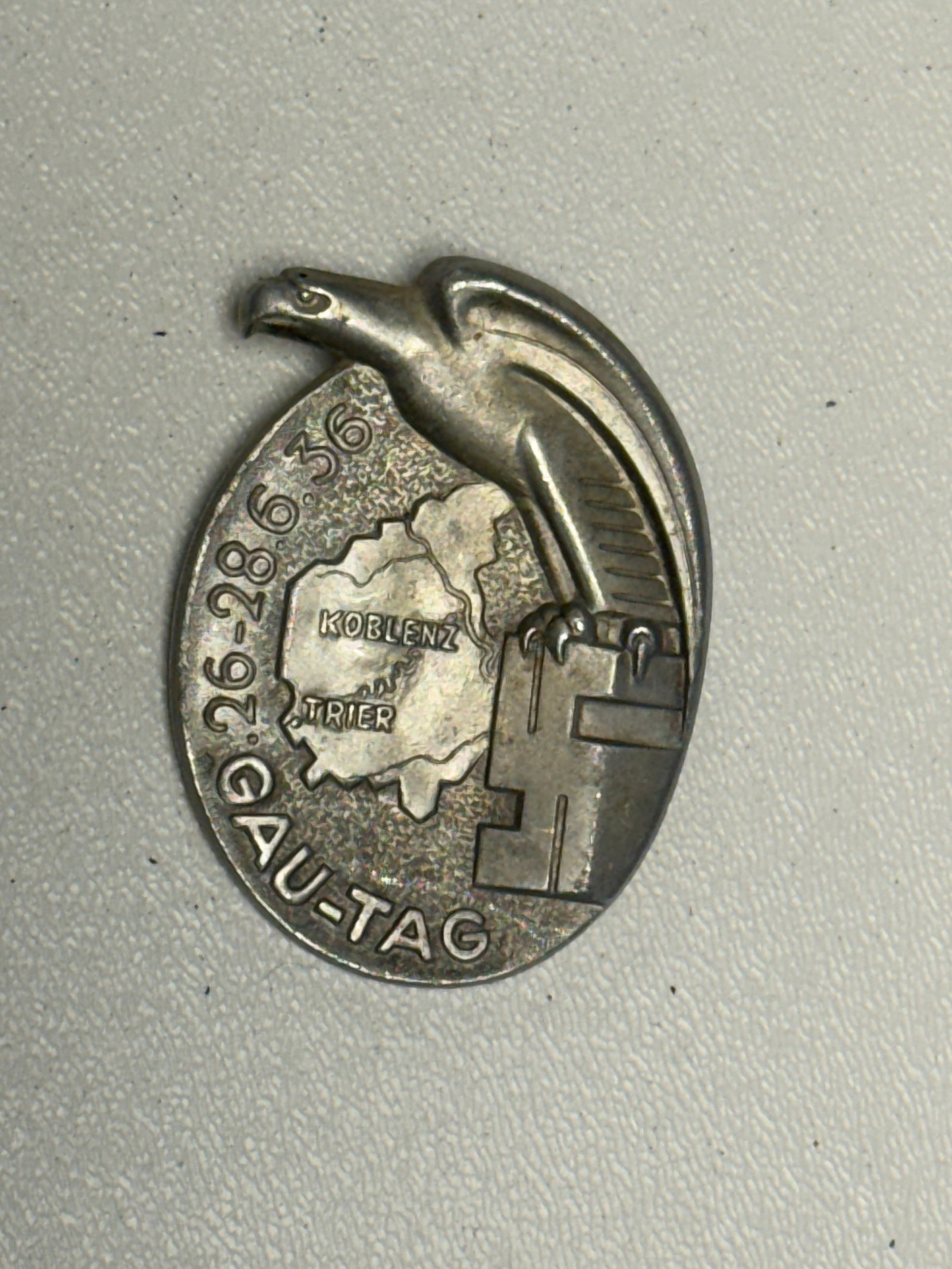 WWII German 1936 Gau-Tag Koblenz-Trier Eagle Rally Badge: German political rally badge dated 26–28 June 1936 and prominently inscribed “GAU-TAG,” with a raised map at the center marked “KOBLENZ an der TRIER.” The design incorporates a large