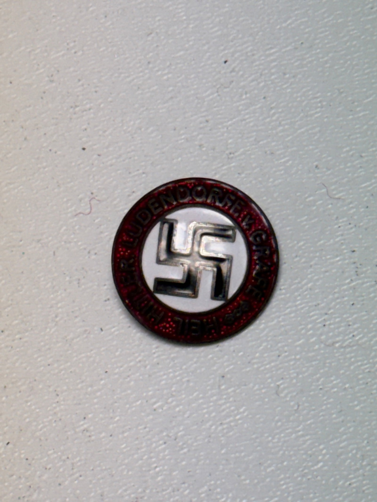WWII German NSDAP Golden Party Badge – M1/72 Marked: WWII German NSDAP Golden Party Badge featuring the central black swastika against a white field, surrounded by a red enameled border bearing the inscription “NATIONAL-SOZIALISTISCHE D.A.P.” Th