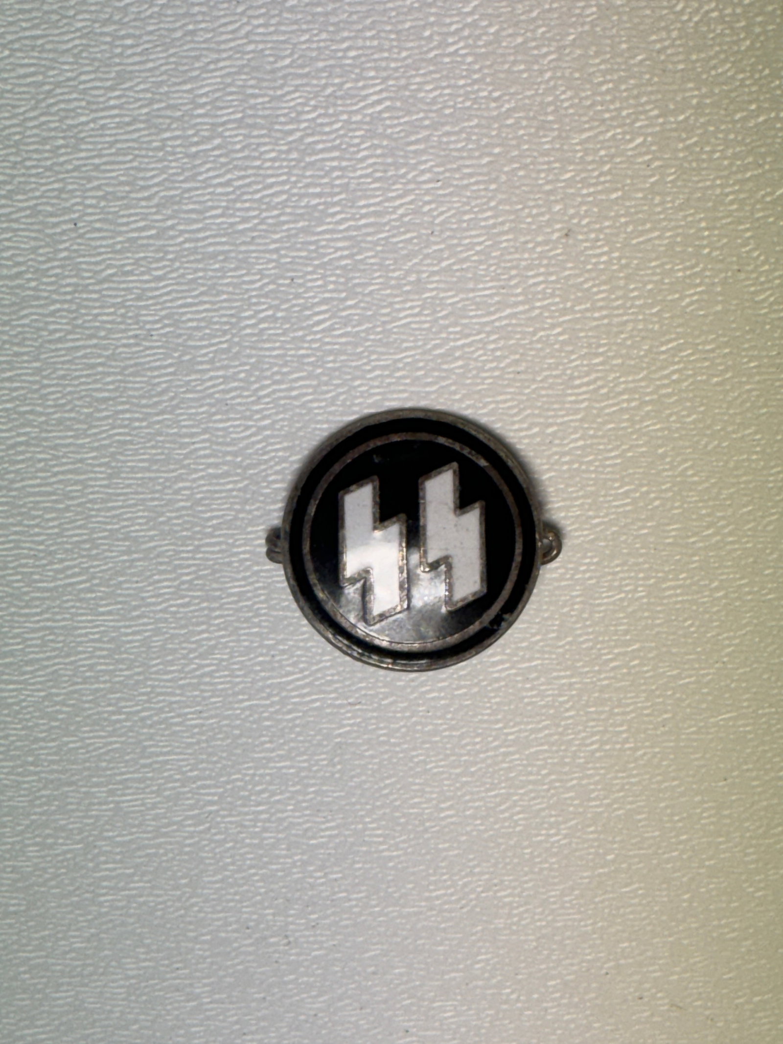 WWII German Waffen-SS SS Runes Enameled Membership Pin RZM Marked: WWII German Waffen-SS circular pin featuring the distinctive double SS runes prominently rendered in a silver-tone finish against a black enameled field, surrounded by a narrow circular border. The re