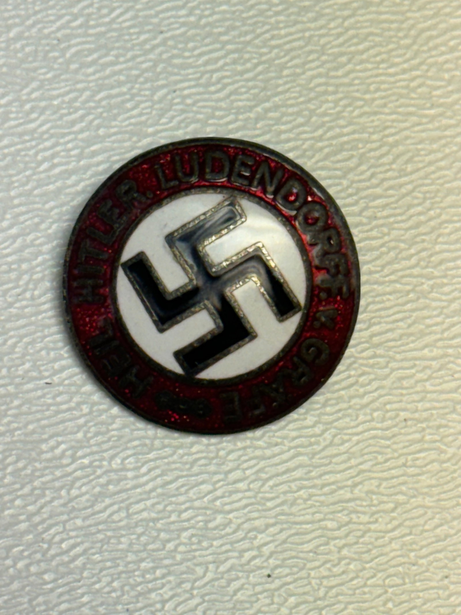 WWII German NSDAP Party Membership Badge M1/73 RZM Ges. Gesch.: WWII German NSDAP membership badge featuring the distinctive circular design with a black swastika centered on a white enamel field and surrounded by a red enamel border bearing the inscription “NAT