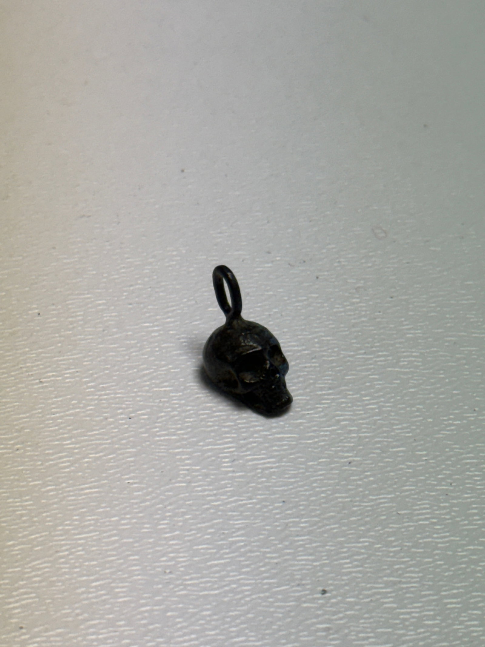 WWII German Waffen-SS Totenkopf Skull Soldier’s Pendant Charm: Small WWII German Waffen-SS themed Totenkopf skull pendant or personal charm featuring a deeply modeled three-dimensional skull with pronounced eye sockets, nasal opening, jaw and facial detailing. Th