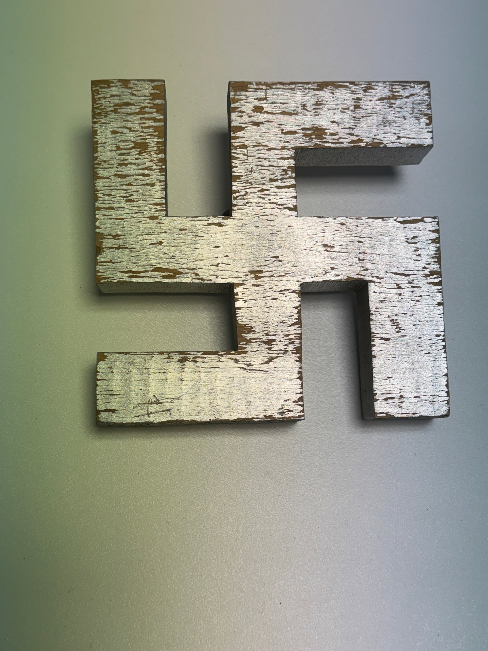 WWII German NSDAP Large Wooden Swastika Wall Display Emblem: Large German swastika-form display emblem constructed from thick wood and finished with a silver-colored painted surface, measuring approximately 8 inches across based on the photographs. The substant