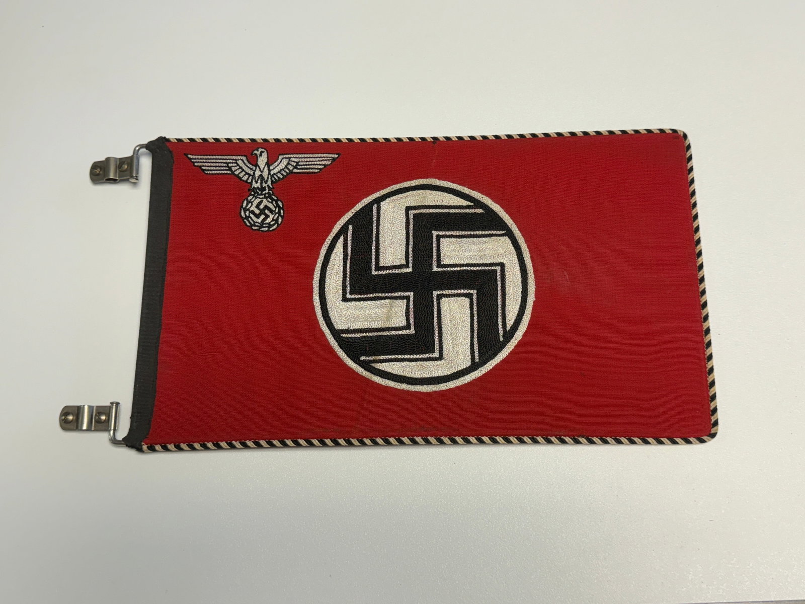 WWII German Third Reich Double-Sided Vehicle Command Flag with Eagle & Swastika: WWII German Third Reich double-sided rectangular command or vehicle flag constructed of red cloth and displaying a large central black swastika within a white circular field, accompanied by a finely e