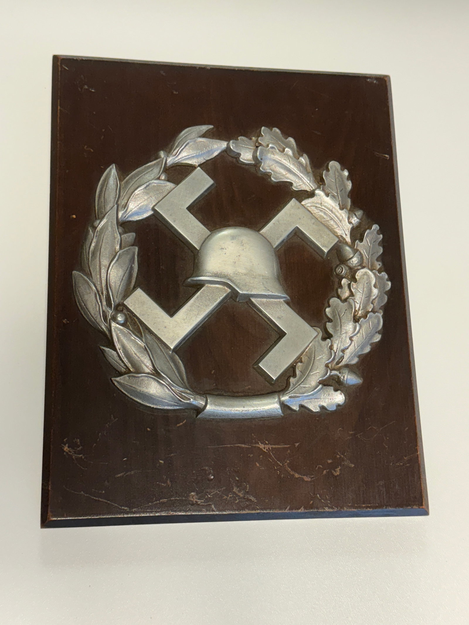 WWII German Army Pioneer Engineer Assault Badge Emblem Wall Plaque: Impressive WWII German military display plaque featuring a large raised metal emblem associated with the German Army Pioneer or combat engineer tradition, mounted prominently to a dark finished wooden