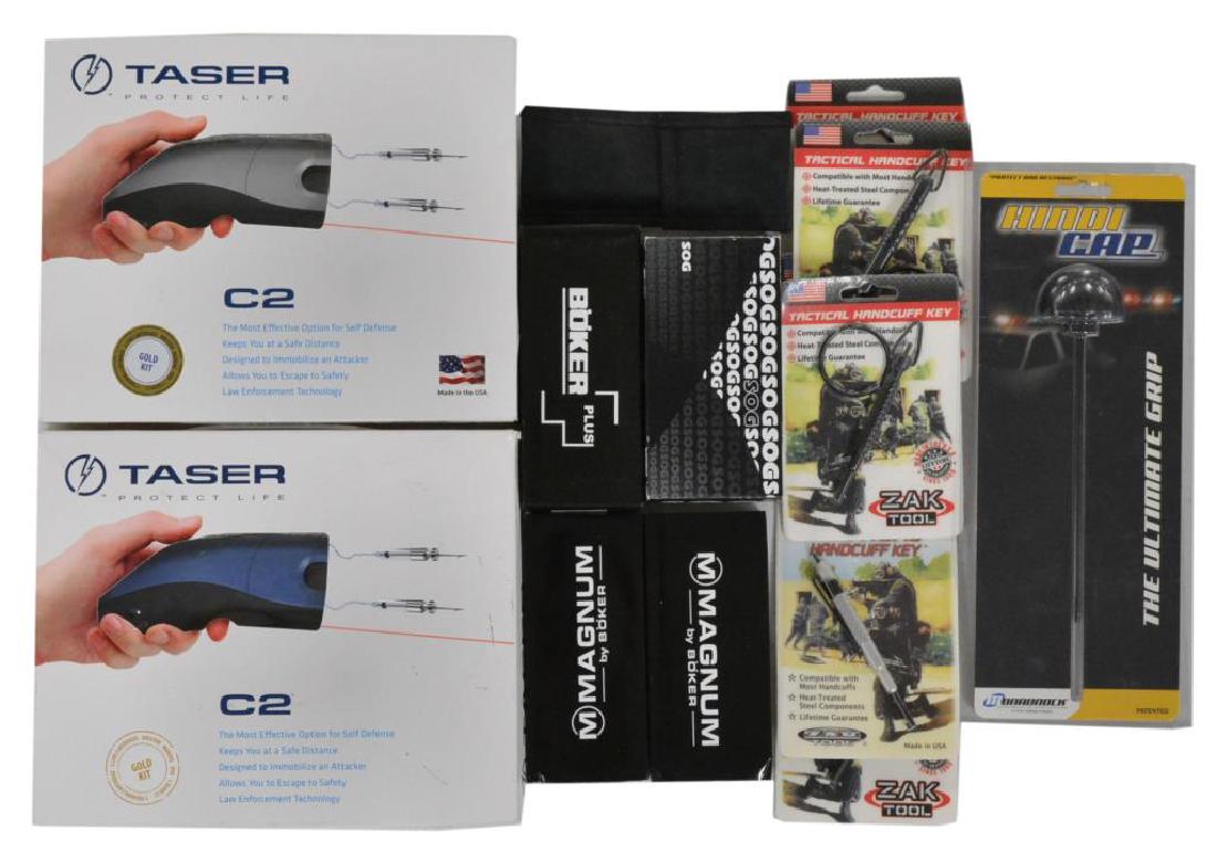 GROUPING OF TASERS, TACTICAL KNIVES, ACCESSORIES &: CUFF KEYS. 2 Taser Protect Life Model Model 39031 C2 Gold Kits. 1 Is blue & 1 is titanium. Includes factory packaging, paperwork, training cartridge, 2 live cartridges, holster, manual & dvd for each.