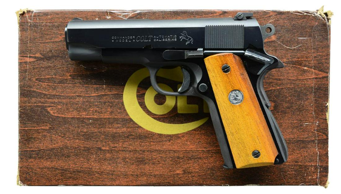 COLT LIGHTWEIGHT COMMANDER SEMI AUTO PISTOL.: Cal. 45 ACP. S# CLW022746. Bbl. 4 1/4". Serrated ramp front sight w/ square notch white outline adj. rear sight. Blue finish. Combat style hammer. Trigger has added wide shoe. 2 Piece wood grips w/ Ra