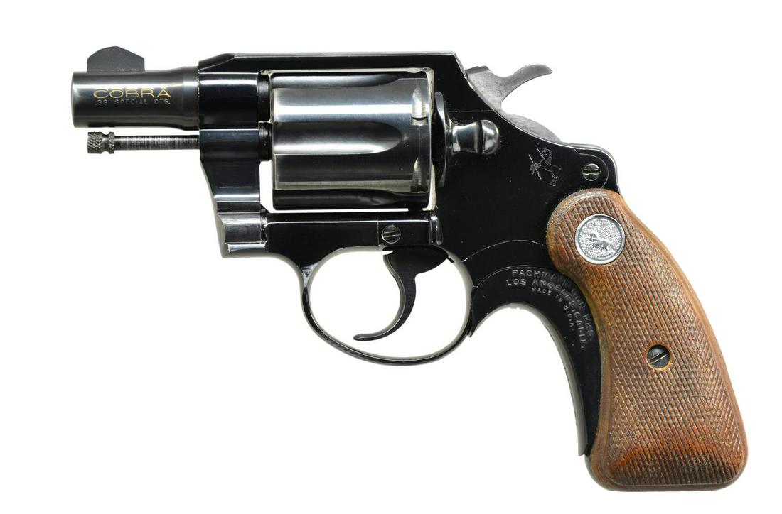 COLT COBRA FIRST ISSUE DA REVOLVER.: Cal. 38 Spl. S# 137399. Bbl. 2" w/ serrated ramp blade front sight. 6 Shot fluted cyl. Rnd. butt alloy frame w/ Rampant Colt medallion on side plate. Narrow spur hammer & grooved trigger. 2 Piece chec