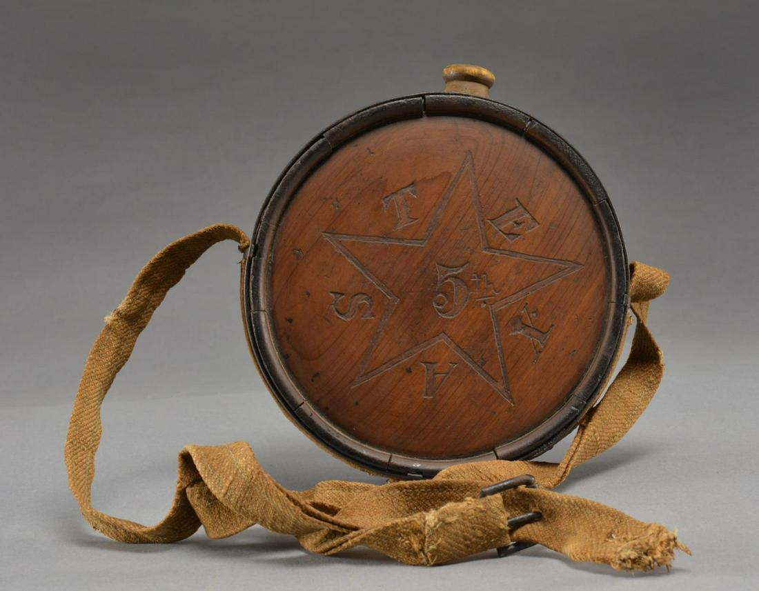 EXTREMELY RARE & FINE IDENTIFIED TEXAS CONFEDERATE: WOOD CANTEEN. Classic Confederate cedar wood 7.25" x 2.5", iron bands & sling hooks, rare cotton canvas sling w/ roller buckle. Canteen is nicely carved w/ star enclosing â€œ5thâ€œ & letters �