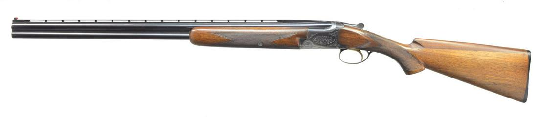 BROWNING GRADE I SUPERPOSED O/U SHOTGUN.: Cal. 28 Ga., 2 3/4". S# 9F24. Bbls. 26 1/2" w/ lightning VR. Red target front sight w/ white mid bead. Fixed Skeet & Skeet chokes. Blued boxlock action w/ Grade I scroll engraving. Gold finished SST. 